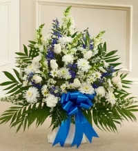 Blue &amp; White Serenity Floral Basket - A peaceful and elegant sympathy floral basket featuring a serene blend of white daisies, white cremon mums, white roses, blue delphinium, and white snapdragons or stock, accented with delicate white asters and fresh greenery.  Finished with a blue ribbon bow, this arrangement conveys comfort, remembrance, and heartfelt sympathy, creating a thoughtful and dignified tribute for honoring a cherished life.