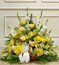 Golden Comfort Sympathy Basket - A warm and uplifting sympathy floral basket featuring a beautiful blend of yellow spider mums, yellow lilies, yellow roses, and white snapdragons, accented with solidago, white asters, and fresh greenery.  Finished with a white ribbon bow, this arrangement conveys comfort, remembrance, and heartfelt sympathy, offering a bright yet respectful tribute to honor and celebrate a cherished life.