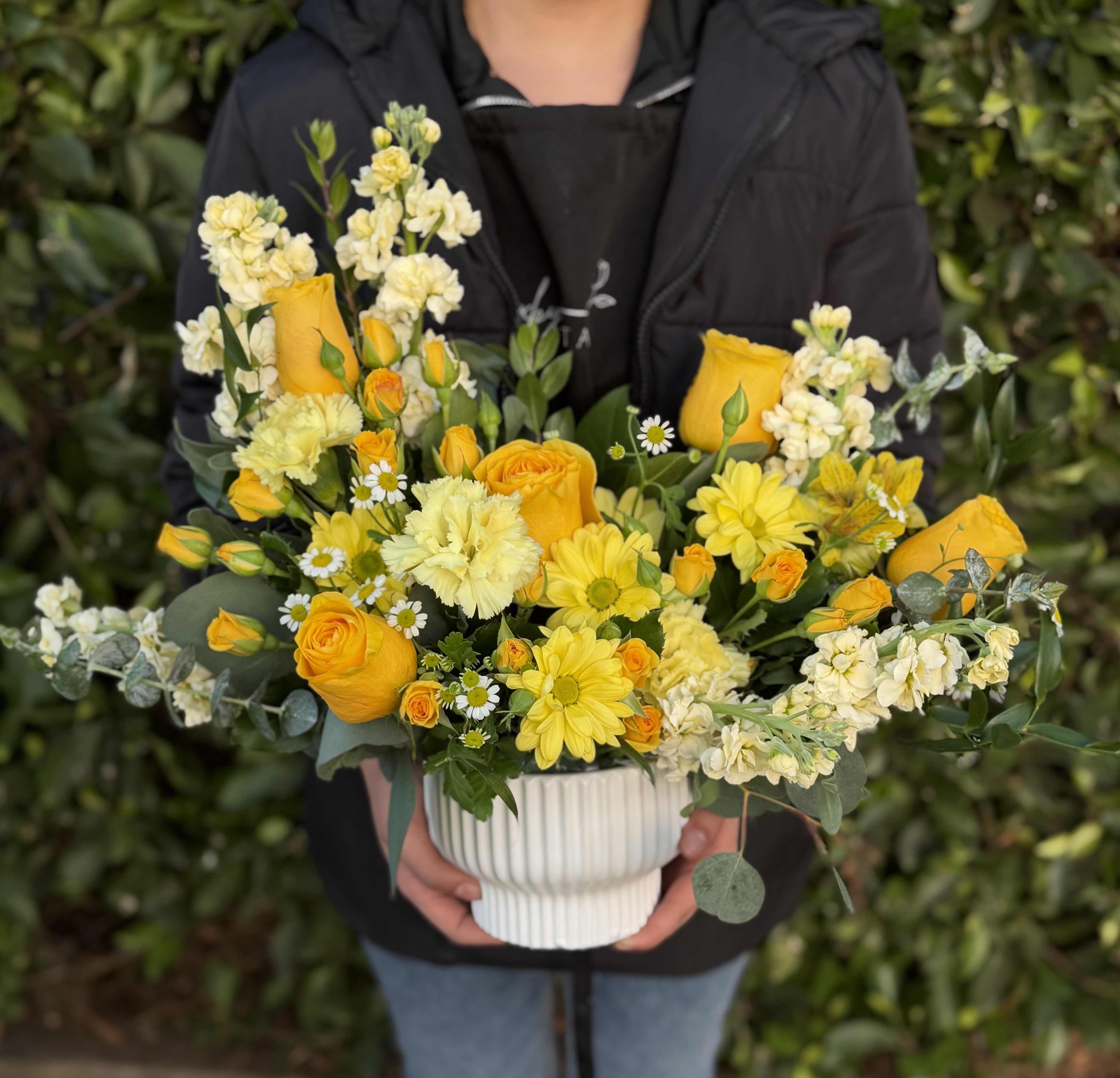 Yellow Meadow Vase - A soft and whimsical mix of yellow blooms and fresh greenery, arranged in a contemporary vase. With its natural flow and delicate details, this piece evokes the charm of a blooming meadow.