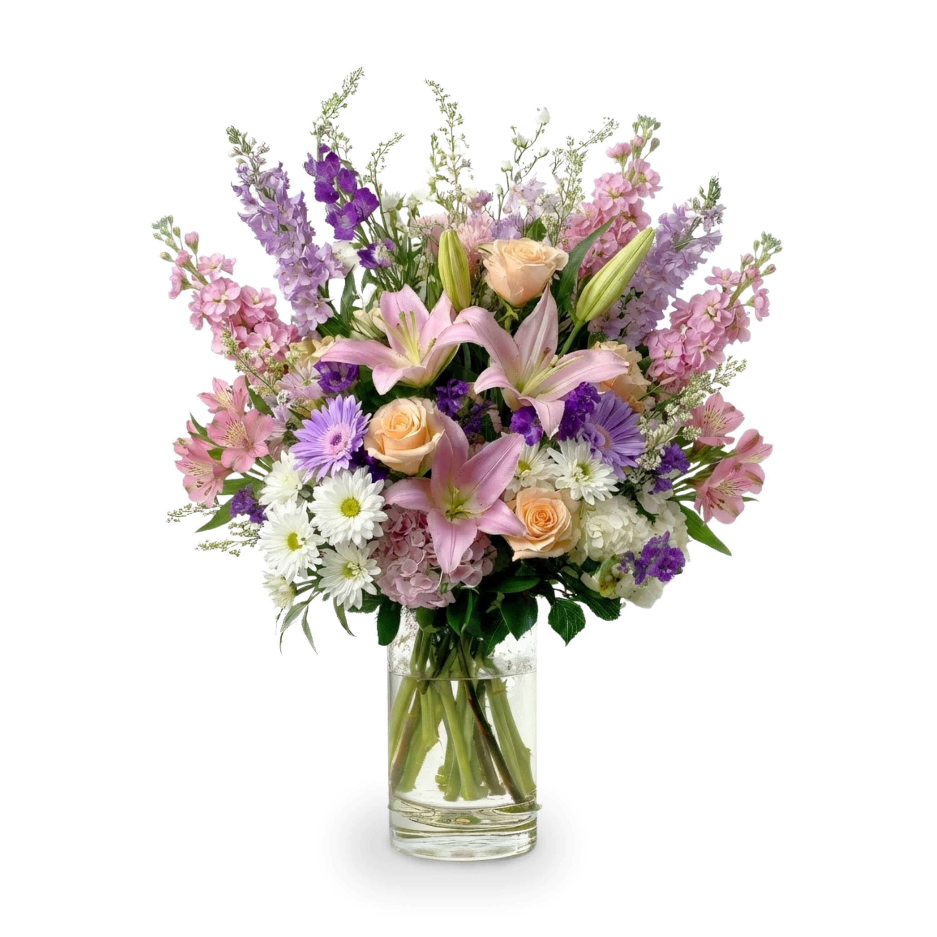 Graceful Blooms for Mom - This elegant Mother’s Day bouquet blends the charm of blush pink lilies, the warmth of soft peach roses, and the cheerful glow of lavender and white daisies. Delphinium and stock add height and texture, while lush hydrangea and delicate filler blooms create fullness and grace. Designed in a tall glass vase, it’s a heartfelt expression of love and gratitude, perfect for celebrating the most important woman in your life.