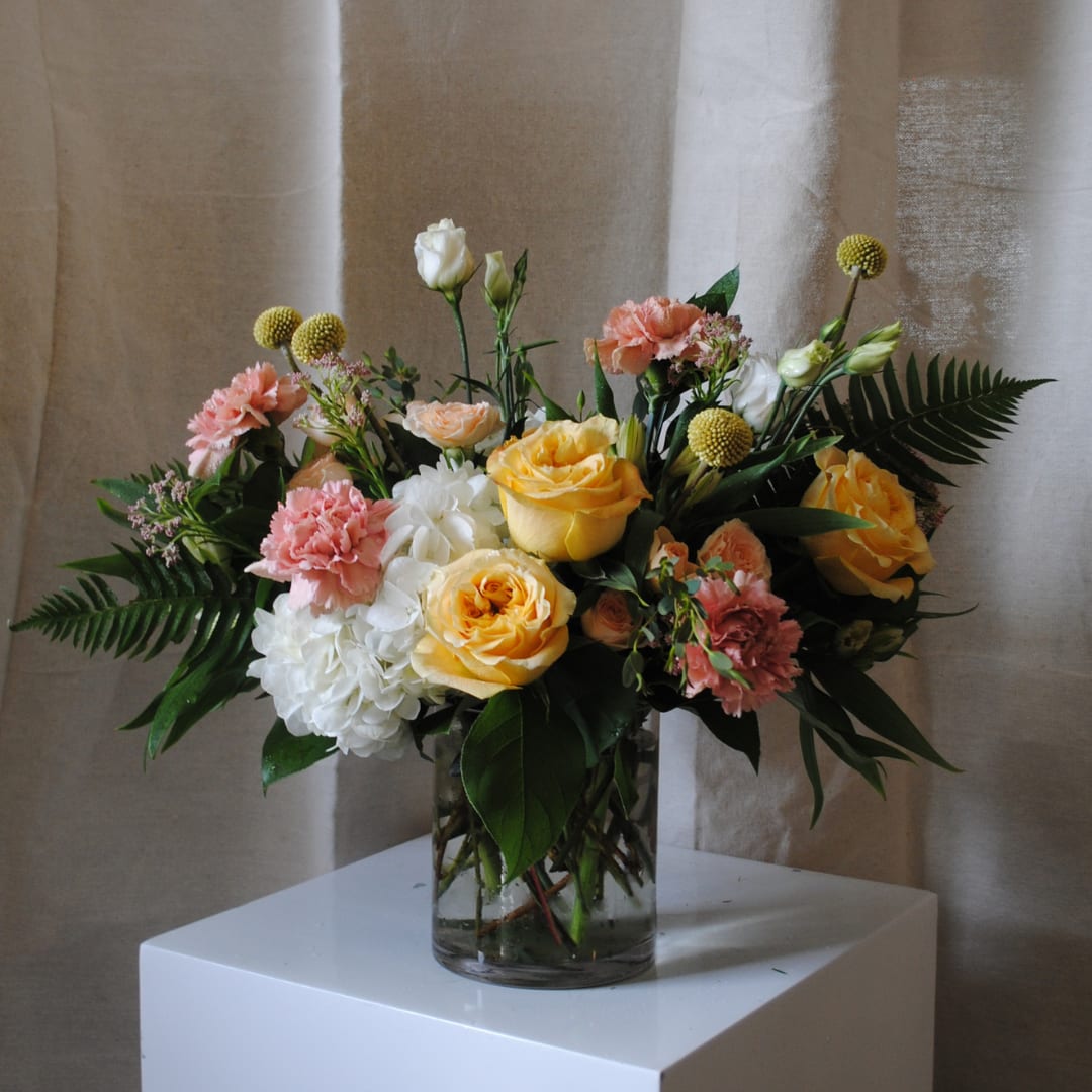Buttercream - A muted mix of yellow, peach and white blooms artfully designed in a clear glass vase!  Flower types will vary depending on season and availability! 