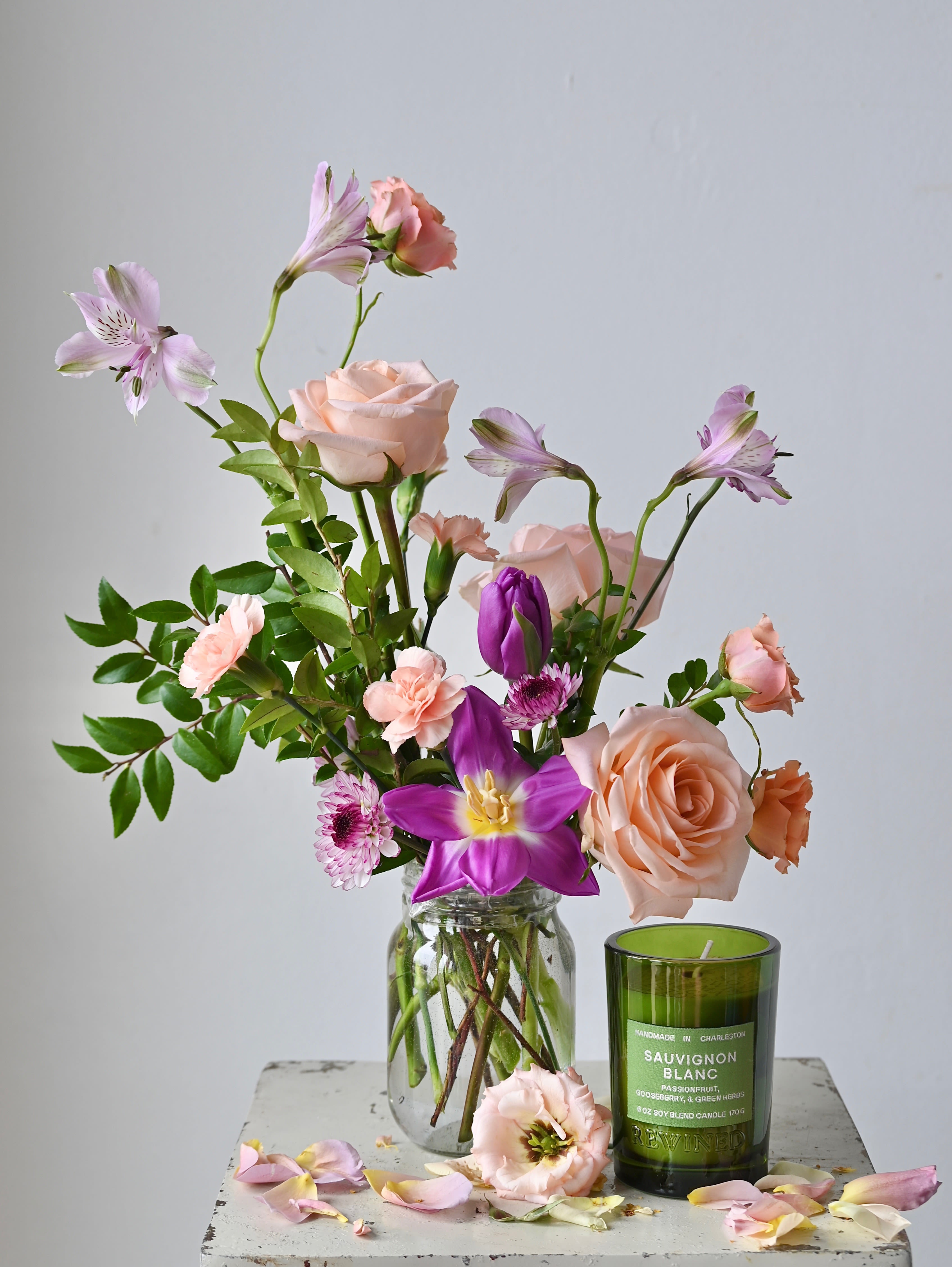 THE HOSTESS BUNDLE  - A fun take on flowers and wine, this arrangement is designed in a mason jar and accompanied by a deliciously fragrant Rewined Candle, hand-selected by one of our staff members.  *Please note that our selection of flowers and color palette changes weekly.