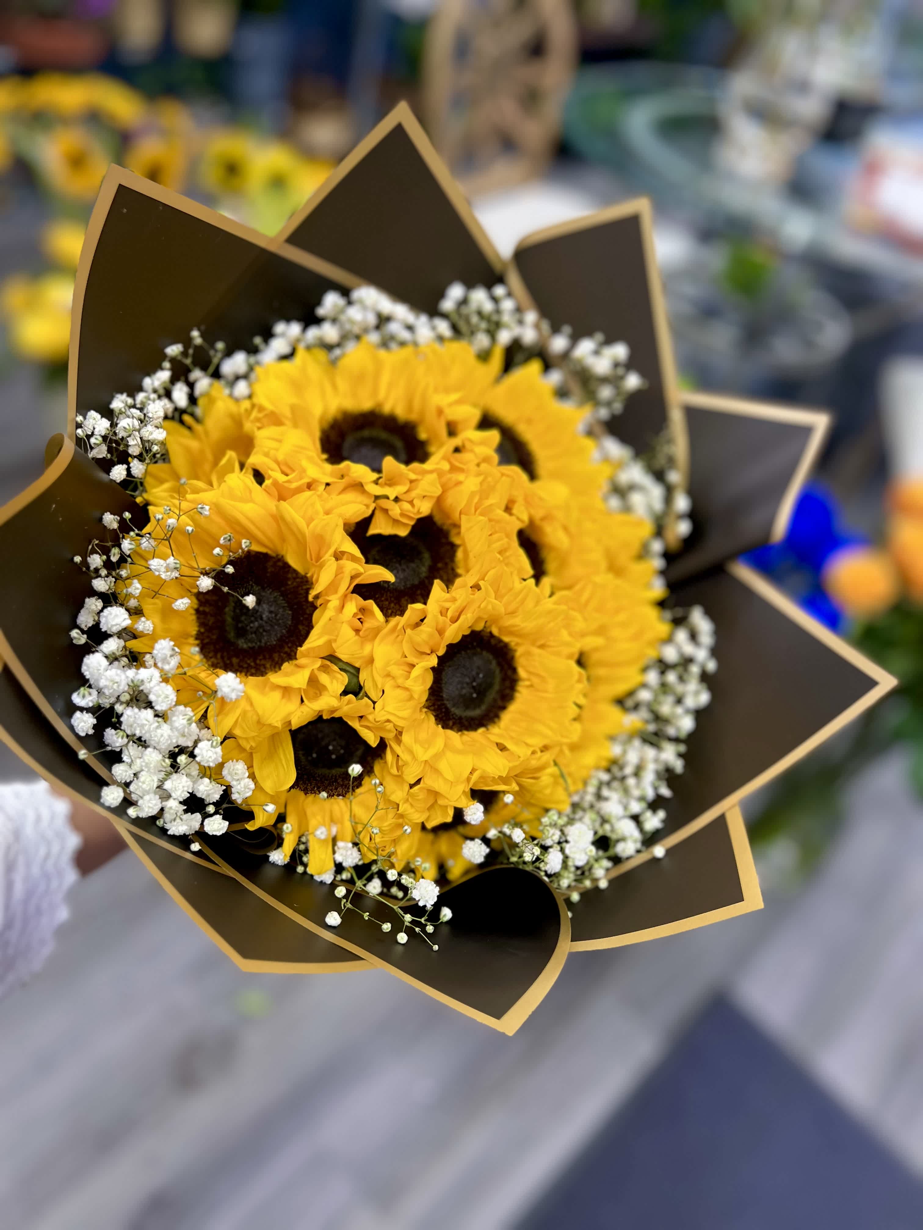 Sol Radiante  - " 'Sol Radiante' translates to 'Radiant Sun' in English, capturing the essence of a bouquet featuring sunflowers. This bouquet embodies the vibrant energy and warmth of sunflowers, known for their cheerful yellow petals and striking appearance. Perfect for bringing sunshine into any room or occasion, it's a delightful choice to brighten someone's days.” 12 Sun Flowers 