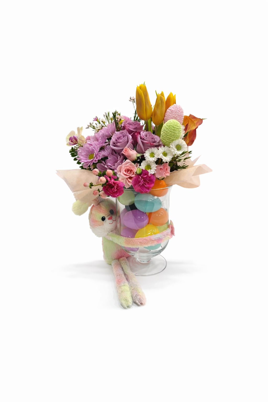 Bunny Bliss | Designer Choice - Celebrate the season with this vibrant Easter-inspired arrangement, beautifully designed in a glass vase filled with colorful Easter eggs and accompanied by an adorable plush bunny. A perfect mix of spring florals and festive charm to brighten any space!   Flower varieties, bunny color, and egg colors may vary based on availability, but the joyful and festive design will remain.   Perfect for: Easter gifts, spring celebrations, and spreading seasonal joy!