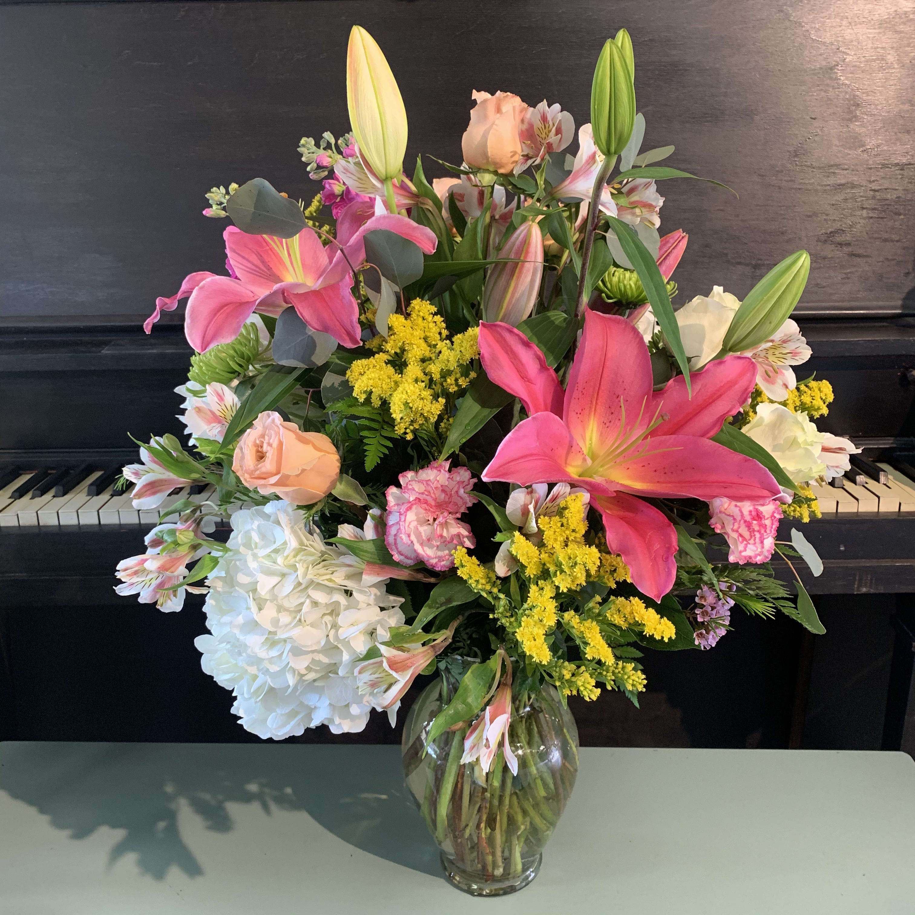 Full of Color Vase  - A bright and colorful arrangement mixed with the freshest of flowers. These will light up a room and bring a smile to anyone’s face. The arrangement in photo shows the size and variety of flowers that the arrangement will have. Colors/ florals WILL vary but match the overall theme of the photo. 