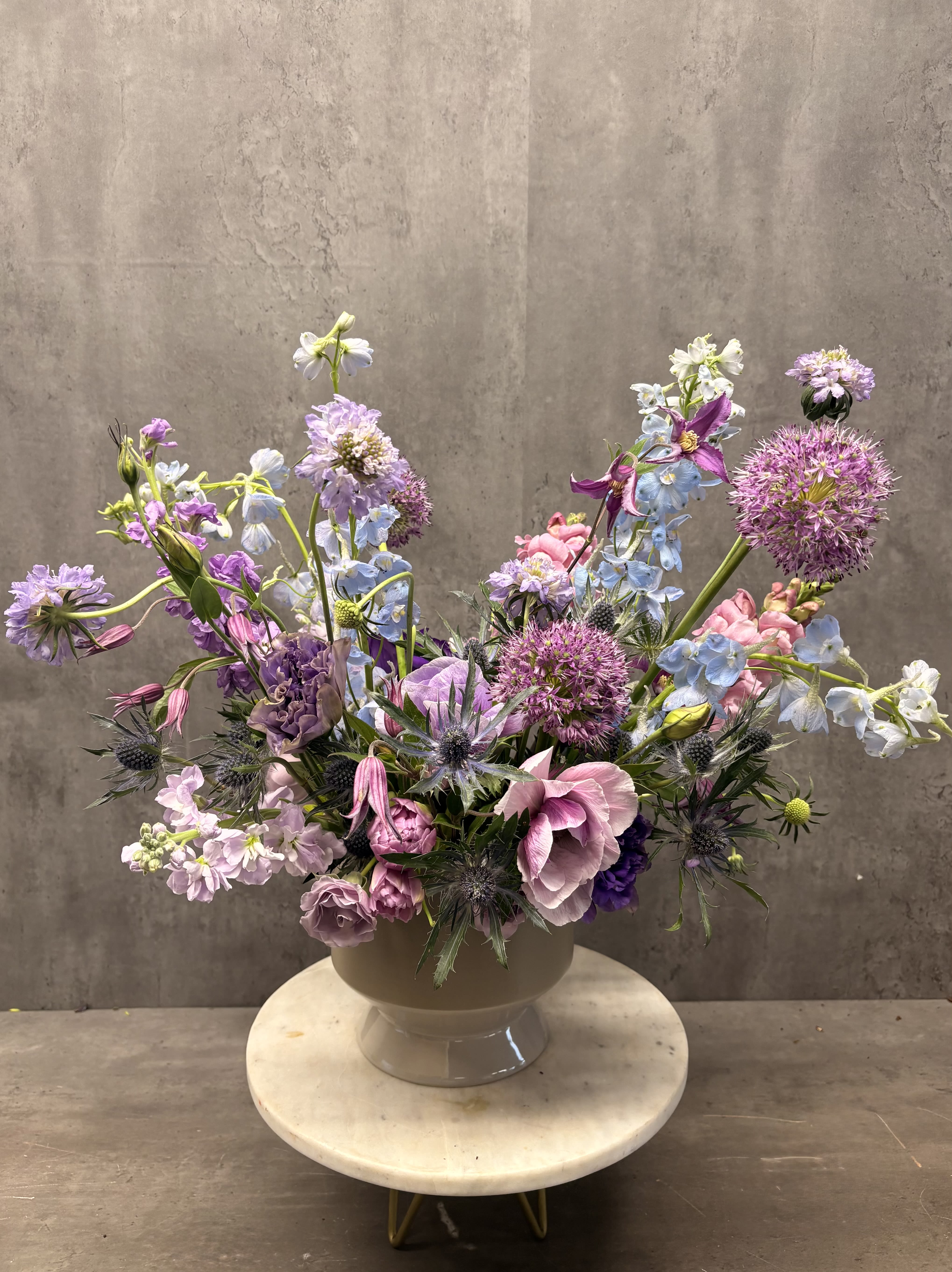 Cosmic Smoke  - A moody arrangement that blends blues and purple with a smokey grey ceramic vase. Created with premium seasonal flowers. 
