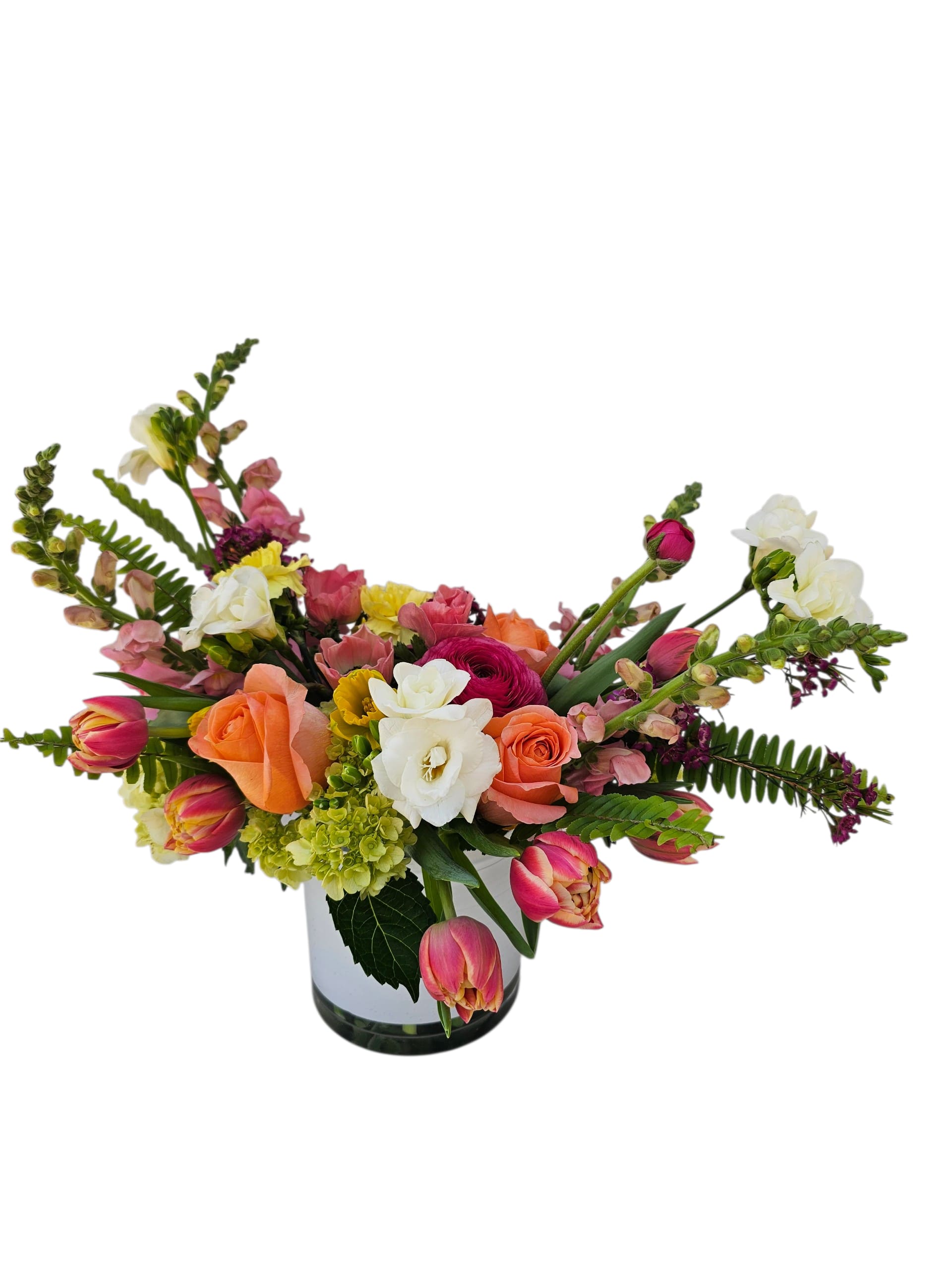 Sunset Glow - A cheerful burst of sunset hues! This airy, modern arrangement mixes sunny yellows, juicy peaches, and bright pops of color in a crisp white low cylinder vase. Light, fresh, and full of glow—it’s like golden hour in bloom.