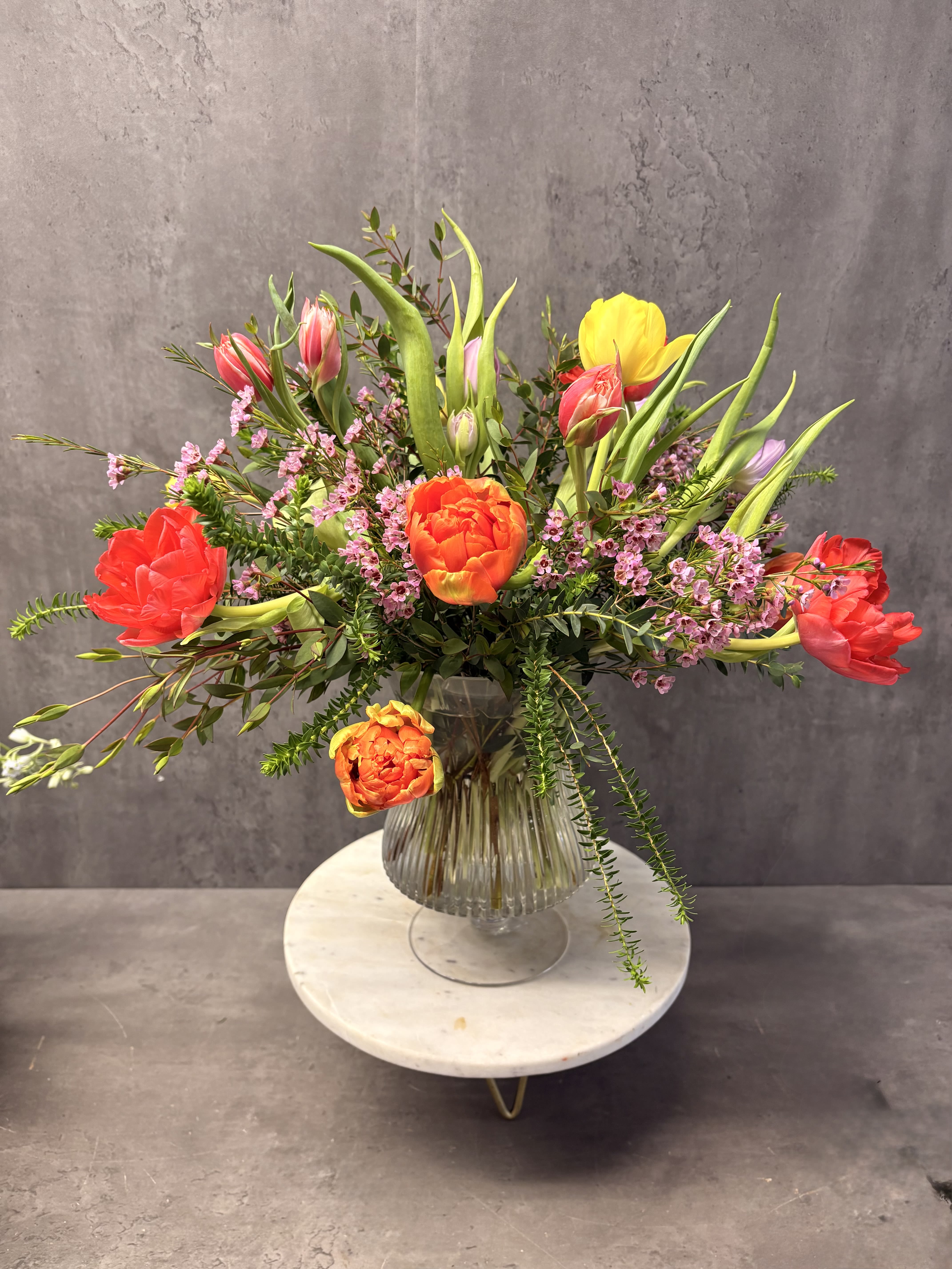 Tulips  - A beautiful display of double tulips in a variety of colors, created in a glass compote vase. Color combination will vary. 