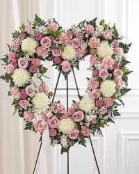 Gentle Heart Spray - A graceful and elegant open heart standing spray designed in soft pink and white tones. This beautiful arrangement features a harmonious blend of chrysanthemums, carnations, roses, and spray roses, complemented by stock and lush fresh greens. The combination of textures and colors creates a full, balanced, and heartfelt tribute, symbolizing love, remembrance, and peace