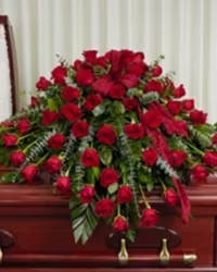 Red Rose Florist Choice Casket Cover - 50 Rose Casket cover with fresh mixed greens and a red bow nestled between the flowers.