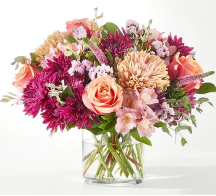 Mixed pink and peach flowers in a clear glass vase