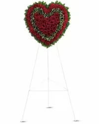 Passionate Heart Spray - A bold and heartfelt standing spray designed in the shape of a heart. This elegant arrangement features rich red roses and red carnations, beautifully accented with lush fresh greens for depth and contrast. The classic design creates a powerful expression of love, devotion, and remembrance.