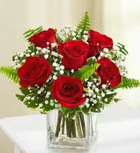 Chic Rose Cube - A sleek and stylish arrangement featuring a half dozen rich red roses, tightly arranged in a contemporary clear glass cube vase. Accented with delicate baby’s breath or white asters and complemented by fresh greens, this design offers a perfect blend of classic romance and modern elegance.