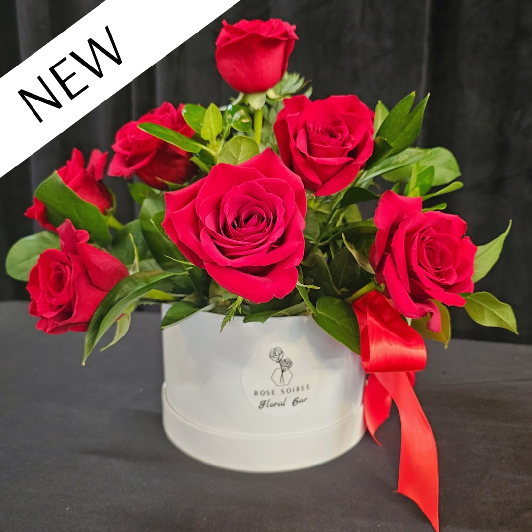 Queen of Sparkles - Bold, glamorous, and impossible to ignore.  The Queen of Sparkles features a lush arrangement of vibrant red roses styled in our signature hatbox, accented with subtle sparkle for a dramatic, eye-catching finish.  Designed for moments that call for something extra, this arrangement is perfect for romantic gestures, celebrations, or when you want to go beyond the expected.  Floral varieties may include premium roses and seasonal greenery. Accents may vary slightly while maintaining the overall bold and elevated design.  Standard Box is approximately 5" x 5.5" Deluxe Box is approximately 6.5" x 6.5" Premium Box is approximately 7.25" x 7.25" 