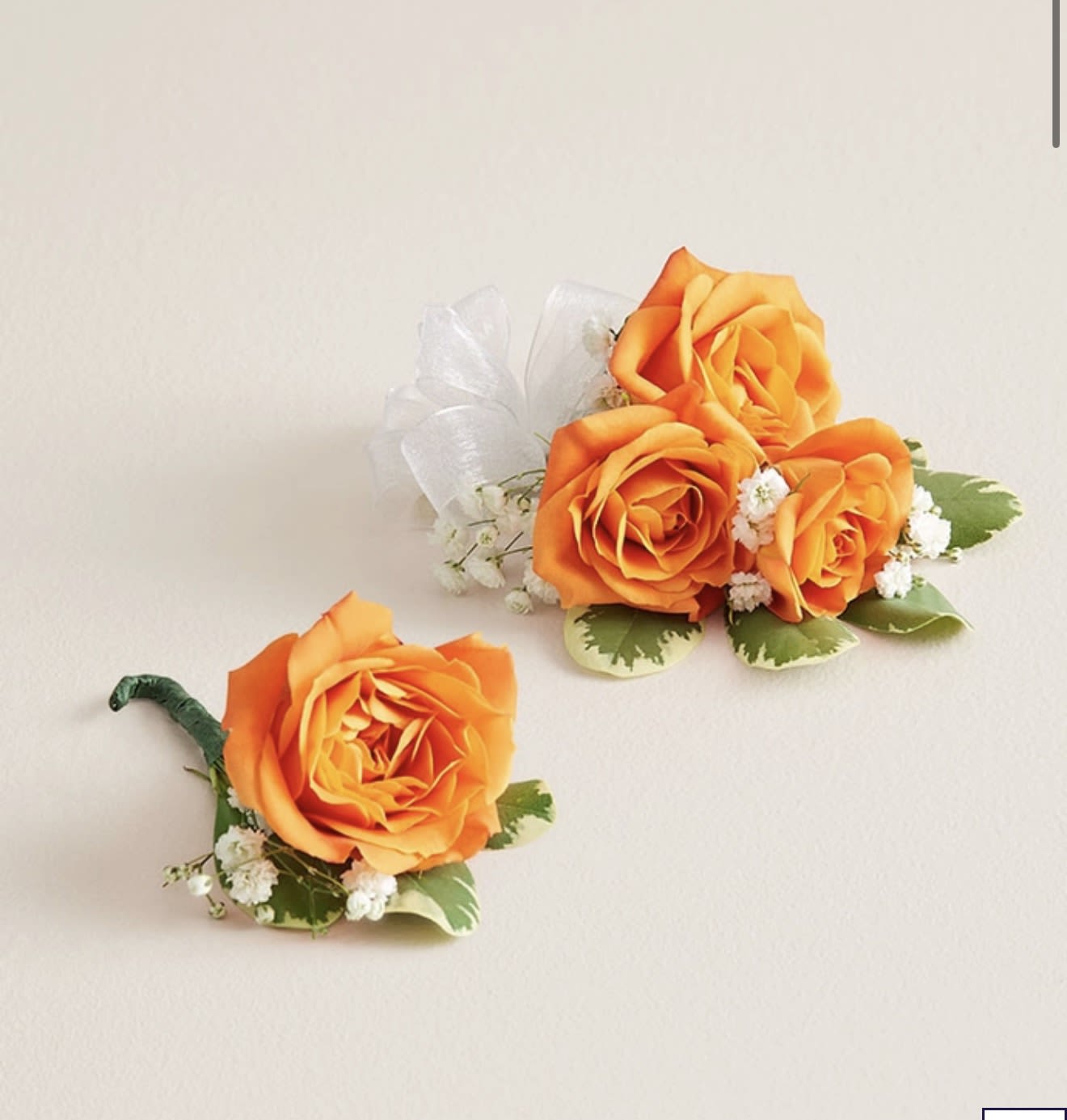 Orange Corsage &amp; Boutonniere Set (White Bow) - This striking corsage and boutonniere set, featuring bold bright orange blooms, is thoughtfully designed to pair perfectly, creating a polished and harmonious look for any special occasion. Each piece showcases carefully selected bright orange flowers and accents, offering a vibrant and refined touch that complements your ensemble beautifully.