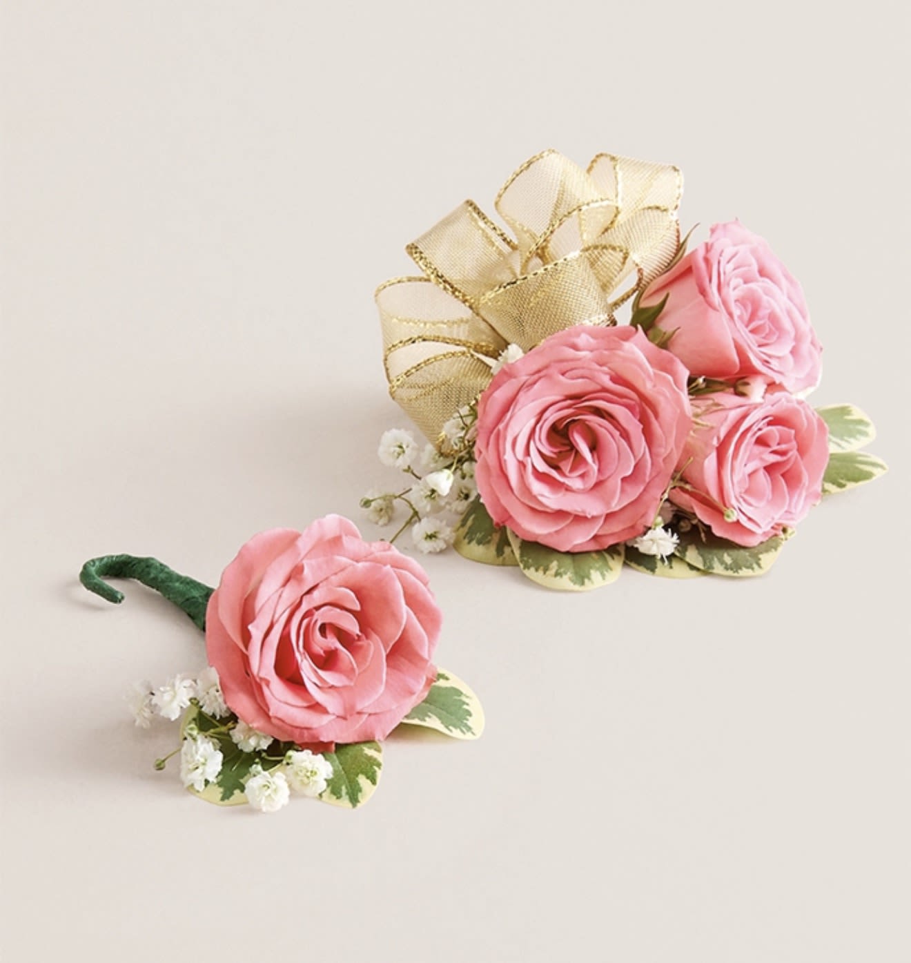Light Pink Corsage &amp; Boutonniere Set (Gold Bow) - This striking corsage and boutonniere set, featuring delicate light pink blooms, is thoughtfully designed to pair perfectly, creating a polished and harmonious look for any special occasion. Each piece showcases carefully selected light pink flowers and accents, offering a vibrant and refined touch that complements your ensemble beautifully.