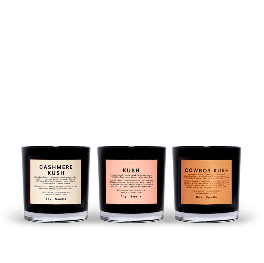 Boy Smells Kush Votive Collection - tiny buds trio  A votive set containing three candles; petite versions of the standard 8.5oz candles. What they have in common is pretty clear—a dank and musky strain runs through them; one is woody, another leathery, all along with our best selling green.  This trio contains—  CASHMERE K*SH   pot flower, cashmere wood, white amber, tulip and musk  K*SH   pot, suede, white musk, tulip and amber  COWBOY K*SH  suede, saffron flower, labdanum, pot leaf, tonka and patchouli     Coconut and beeswax blend with braided cotton wick, in glossy black glass tumbler.   Comes in embossed matte pink sleeve and embossed matte black tray.  3 ounces each (85g). 9 ounces total (255g). 2.5 inches (6.4cm) tall.