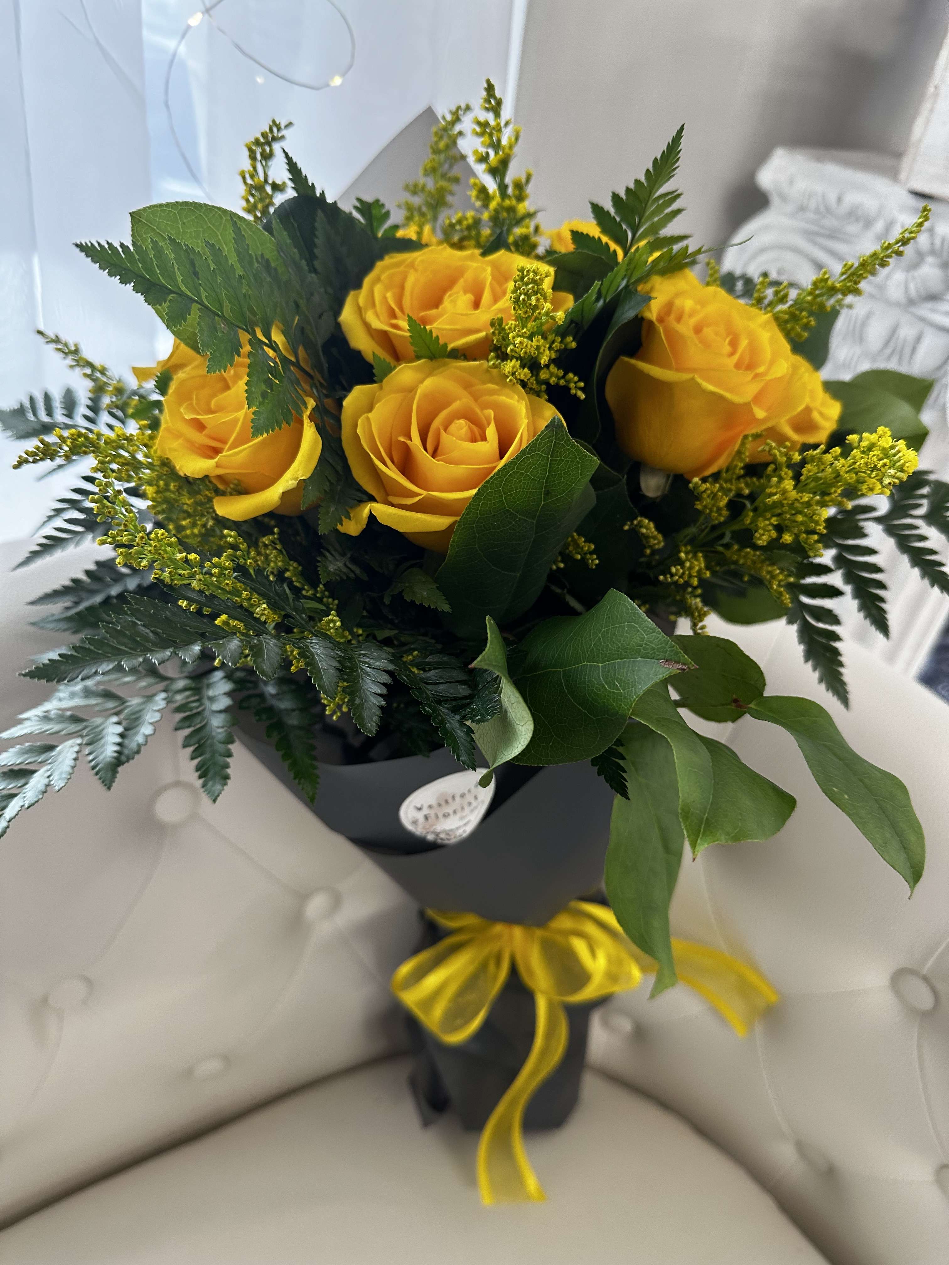 Dozen Yellow Roses wrapped bouquet by Westford Florist Art by Veny - Elevate your gifting experience with the Dozen Yellow Roses Wrapped Bouquet by Westford Florist Art by Veny. This exquisite arrangement features twelve vibrant yellow roses, elegantly wrapped to create a captivating presentation that is perfect for any occasion—be it a birthday celebration, an anniversary toast, or simply a heartfelt gesture. Symbolizing friendship, joy, and new beginnings, these stunning blooms convey warmth and positivity. Each rose is thoughtfully chosen for its beauty and freshness, ensuring that your thoughtful gift will leave a lasting impression. Brighten someone’s day and celebrate life’s moments with this timeless bouquet from Westford Florist Art by Veny—a true testament to nature's artistry.