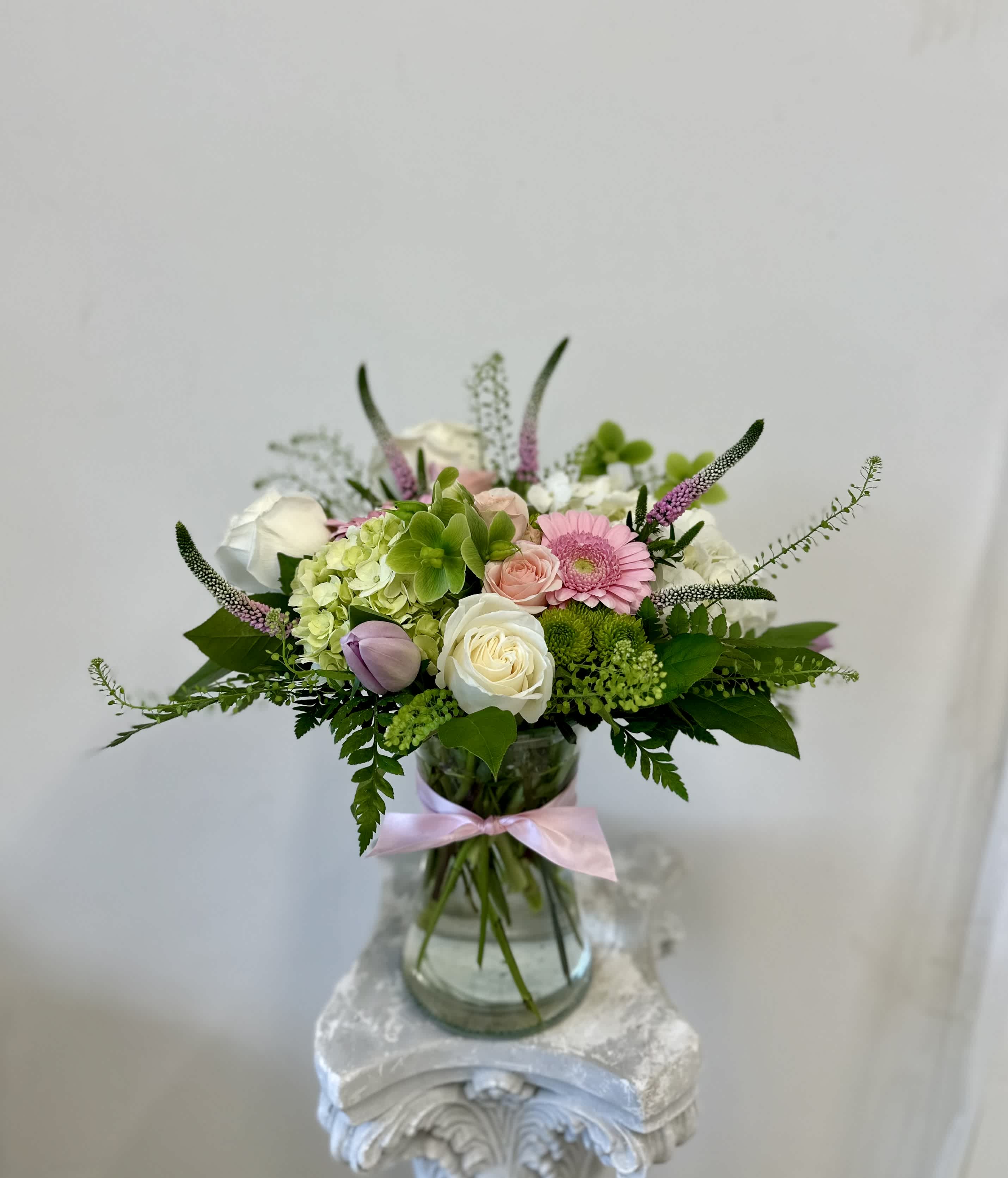 Flowers for Mom by Westford Florist Art by Veny - Indulge in the exquisite beauty of Flowers for Mom by Westford Florist Art by Veny. Crafted with a harmonious blend of roses, tulips, spray roses, veronica, gerbera daisies, heliborne, and green pom, this luxurious arrangement is designed to captivate and delight. Encased in a tall gathering glass vase, each bloom exudes elegance and sophistication. Let your love blossom and your appreciation flourish as you present this stunning gift to the most important woman in your life. Elevate any occasion with Flowers for Mom by Westford Florist - because she deserves nothing but the best. Treat her like royalty with this opulent floral masterpiece.