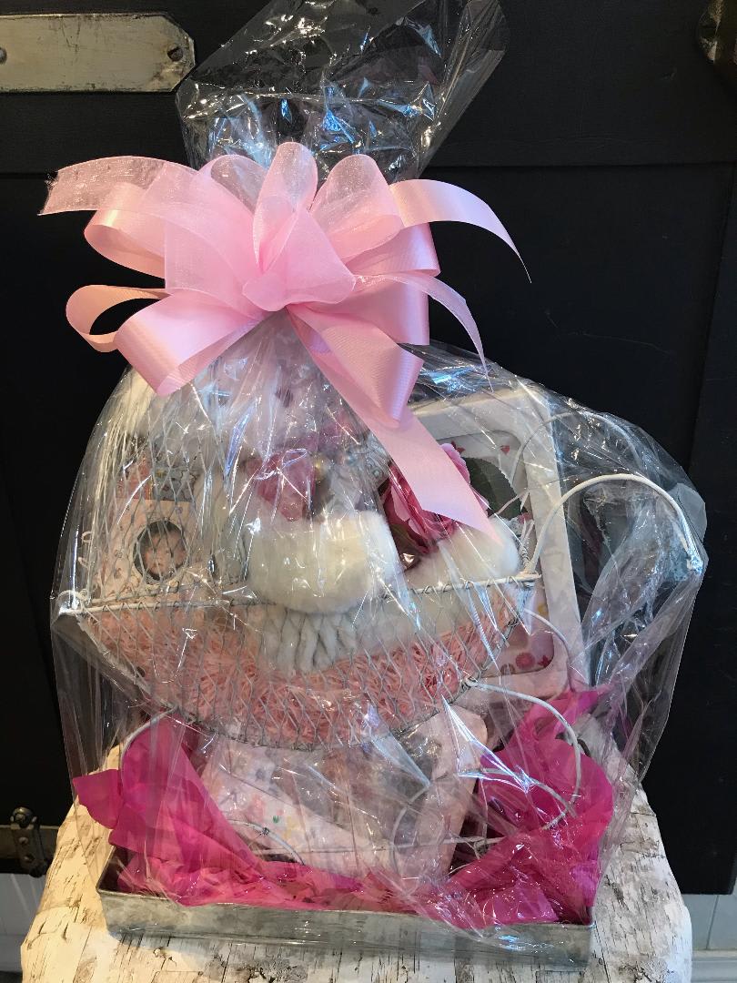 Baby Girl Buggy Basket - Enjoy this Wire Baby Buggy sitting in a tin container filled with assorted gifts for mom and baby! This comes with a 8x10 light up frame, a plush white bear, a 4x6 photo frame, mini tin with candy, key photo ring, a pink silk rose, a beautiful "baby" ornament, all wrapped up with a bow!