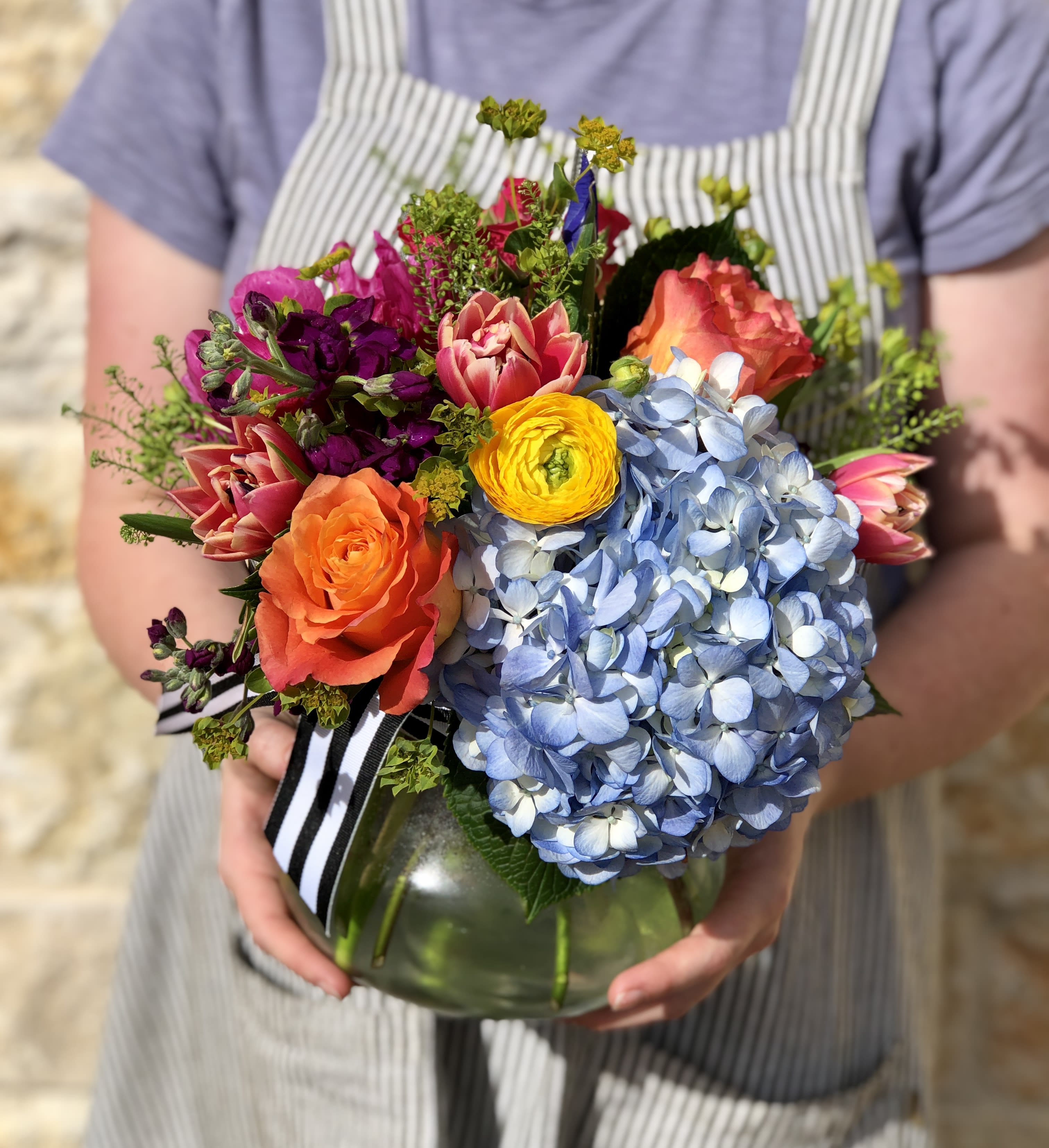Seasonal Vibrant Garden - A bright and colorful seasonal mix, designed low and dense in our signature English garden style.  Arranged in a clear glass vase. Overall design is approx. 11" x 11"  Floral varieties may vary but will be of similar quality and style.     