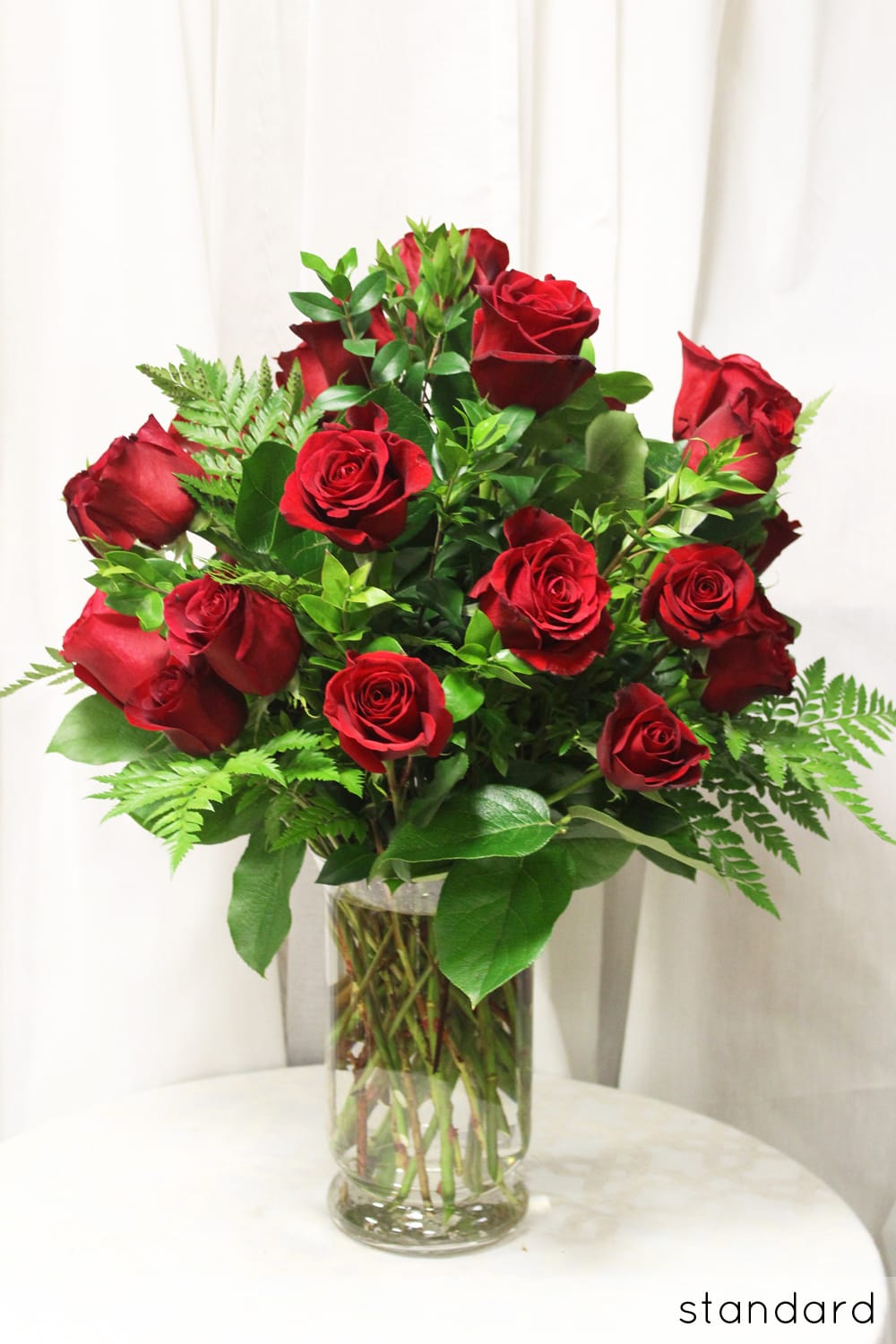 2 Dozen Red Roses - The ultimate classic in romance and passion! Twenty-four beautiful Ecuadorian red roses designed with premium filler.  Upgrade to Deluxe and we will add white orchids and lilies to make a truly romantic arrangement.