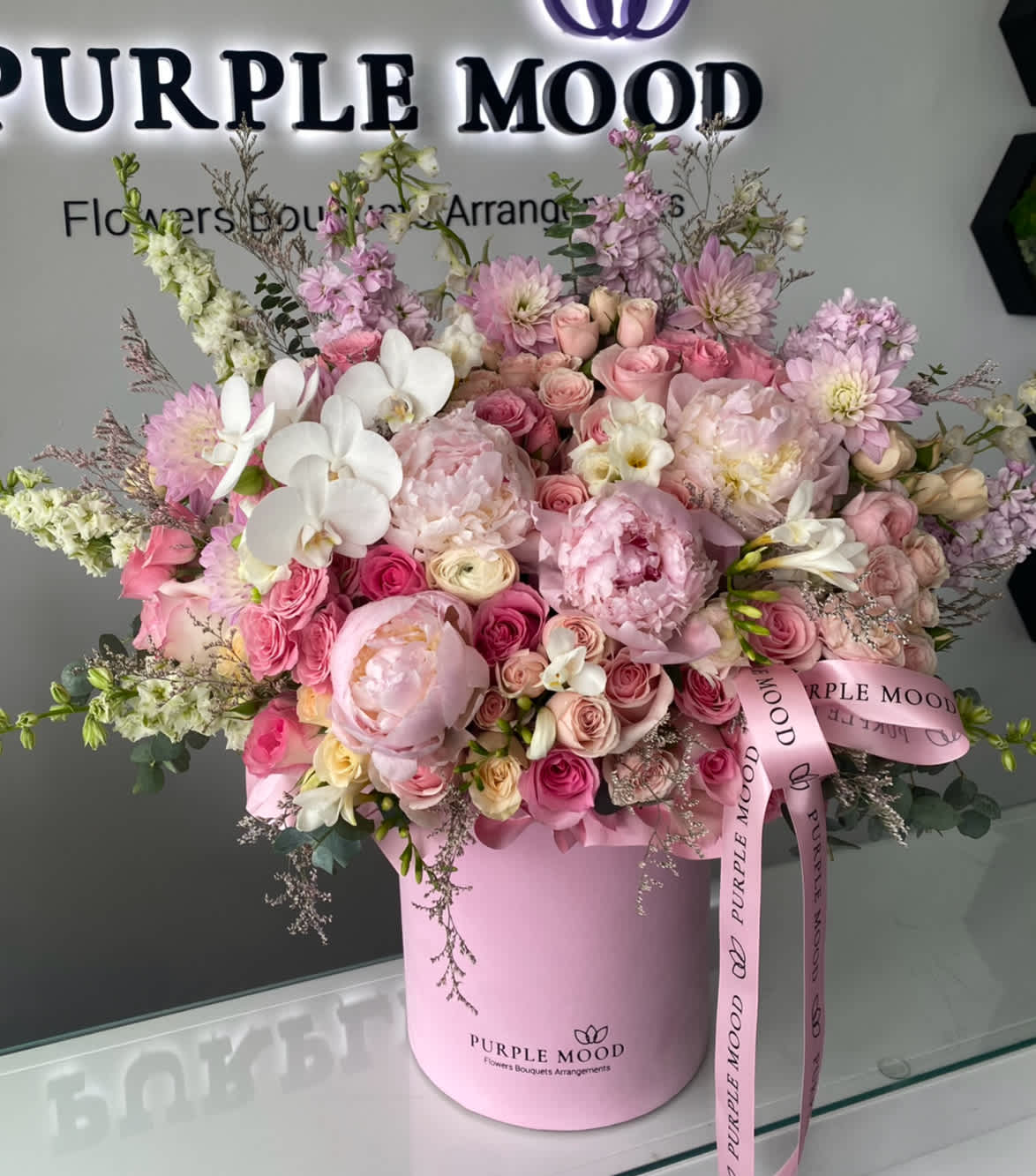 Like you box - Standard container size - D8.25'x H9.5' Deluxe container size - D10.5'x H12.25'  Charming, romantic, and unforgettable — the Like You Box is a luxurious arrangement in soft pinks and blush tones, designed to sweep anyone off their feet. Styled in an elegant hat box and overflowing with blooms, it’s the perfect way to say “I adore you” with flowers.  Key Features:     •    Elegant pink hat box filled with lush premium blooms     •    Finished with a signature ribbon for a refined touch     •    Available in Standard ($295) and Deluxe ($435) sizes     •    A beautiful choice for romantic occasions or grand celebrations