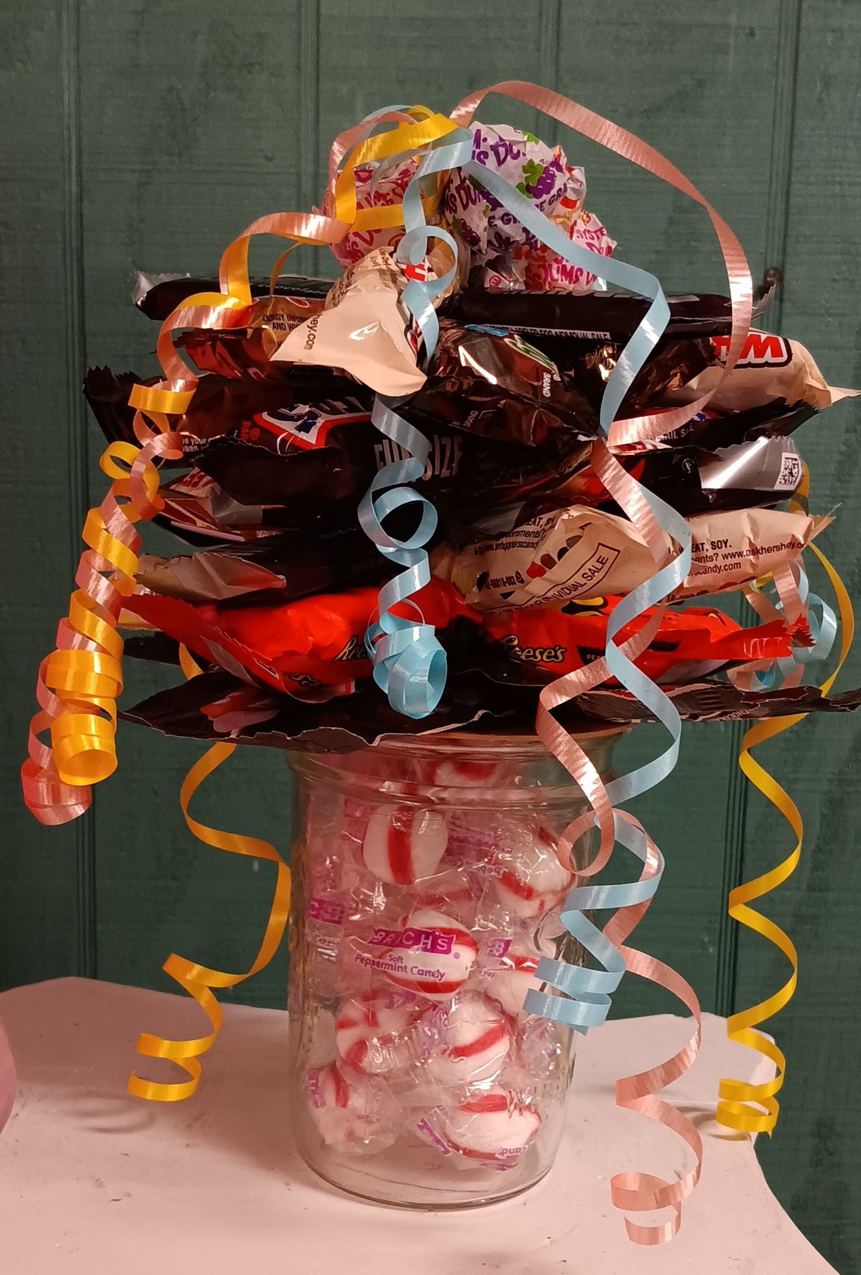 Candy Sundae - Brighten someone’s day with this adorable candy sundae! Packed into a playful, reusable container, it’s a treasure trove of shareable delights. Inside, you’ll find an irresistible mix of colorful candies and rich chocolate treats, carefully curated for maximum joy. To top it off, a whimsical bouquet of lollipops bursts from the top, making it as charming to look at as it is to enjoy. Candies can be customized!   Whether it’s a gift for your special someone, a pick-me-up for an office star, or a sweet surprise for a busy student, this sundae is the perfect way to spread smiles!