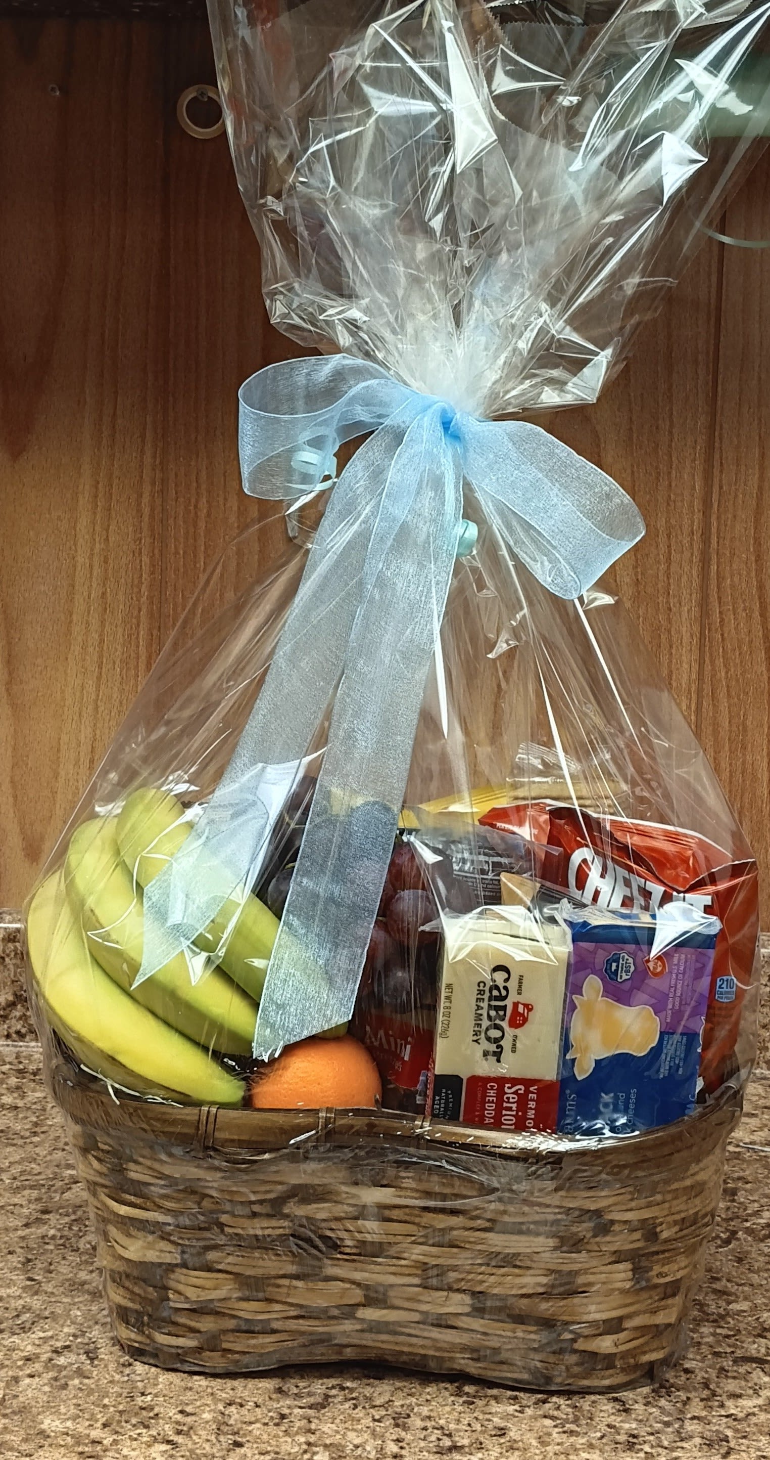 Country Fruit Basket - A perfect gift for any occasion! Our beautifully arranged Fruit Basket is brimming with a delicious assortment of fresh seasonal fruits, fun snacks, and indulgent chocolates. Whether you're celebrating, sending love, or offering comfort, this basket is sure to bring a smile.  Want to add a personal touch? No problem! Simply include any special requests or dietary needs in the special instructions, and we’ll take care of the rest. Otherwise, let our talented designers craft a bountiful and tasty surprise your loved one will adore.  Fresh, flavorful, and fully customizable – a gift that's as thoughtful as it is tasty!