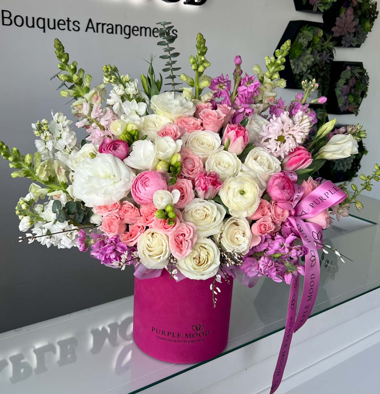 Marmalade Box - Standard container size - D6.75'x H7.5' Deluxe container size - D8.25'x H9.5'  Cheerful and elegant, the Marmalade Box is a stunning blend of soft pastels and creamy whites arranged in a vibrant fuchsia hat box. With its fresh, joyful design, it’s perfect for birthdays, thank-yous, or brightening someone’s day with a burst of color.  Key Features:     •    Arranged in a bold fuchsia hat box for a modern look     •    Finished with a signature ribbon for an elegant detail     •    A lively and stylish gift for any special occasion