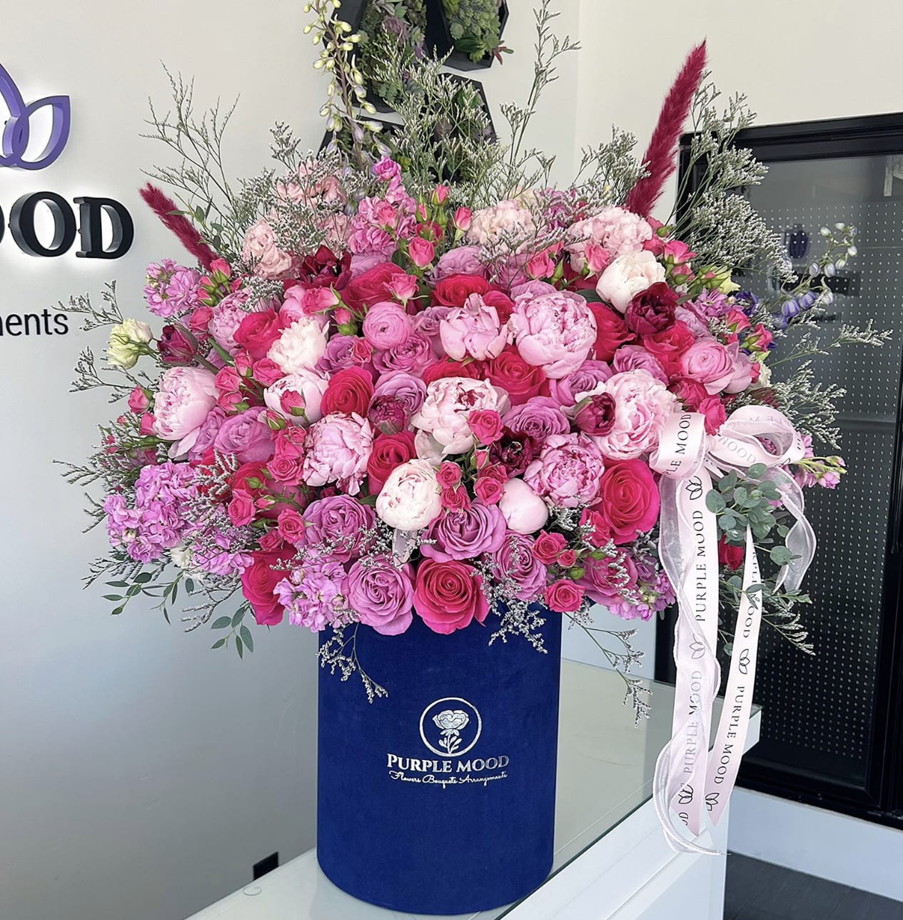 Romance Box - Container size - D10.5'x H12.25'  Romance Box Grand, luxurious, and unforgettable — the Romance Box is a big, show-stopping arrangement that makes a powerful statement of love. Overflowing with vibrant pinks and soft romantic tones, it’s designed to impress and captivate at first sight.      •    Extra-large design in a tall velvet hatbox     •    A lavish blend of bold and delicate hues     •    Perfect for anniversaries, proposals, or grand celebrations     •    A true luxury piece that leaves a lasting impression