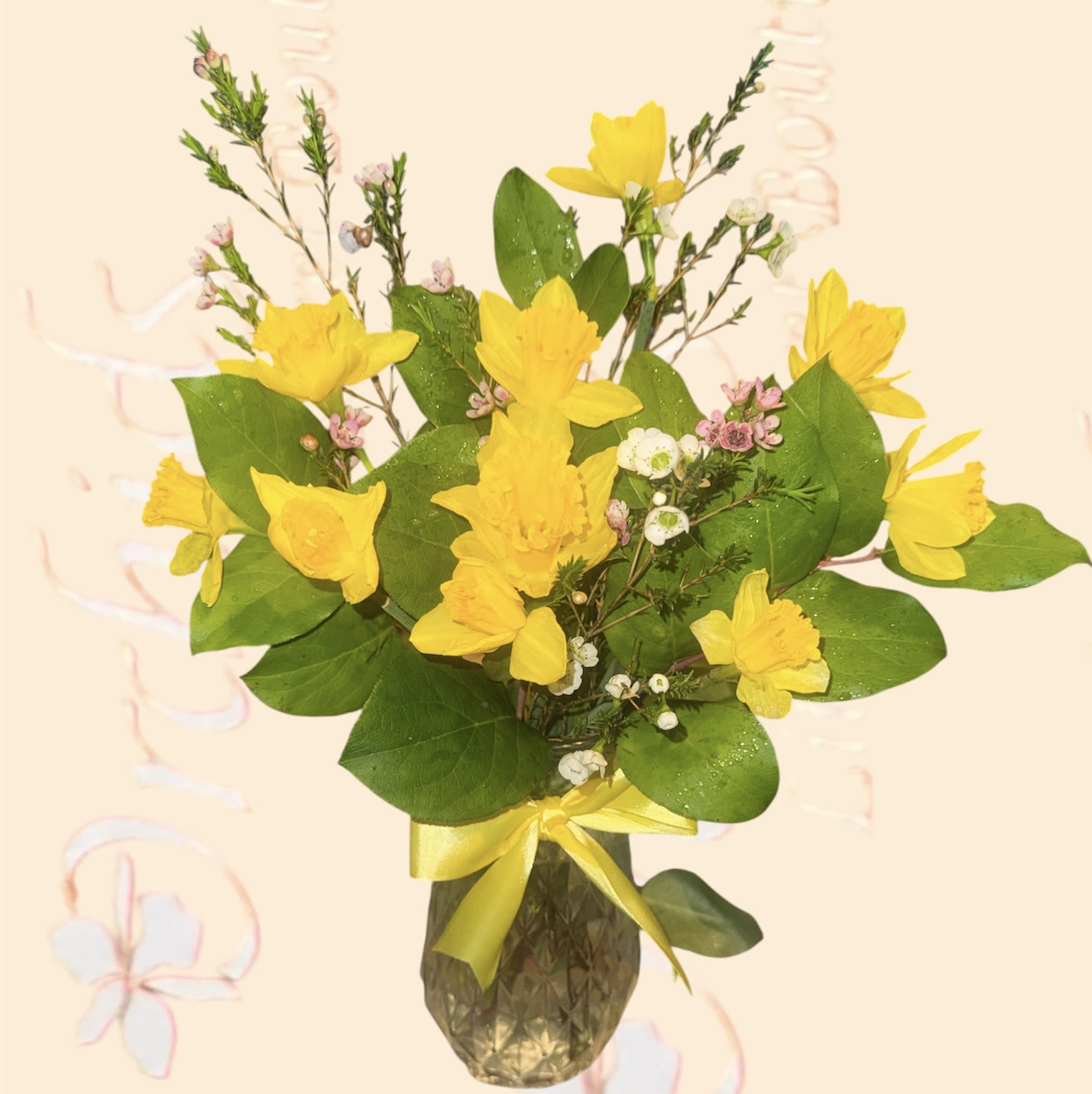  Cheerful Sunny Daffodil Bouquet - Bring a burst of sunshine and spring into your home with this vibrant and cheerful Sunny Daffodil display. This stunning arrangement features a generous cluster of bright yellow daffodils, complemented by lush green foliage and delicate white and pink accent flowers. Presented in a stylish, textured vase and finished with a charming yellow ribbon, this arrangement is ready to brighten any desk or table. Perfect for birthdays, get-well wishes, or simply to bring a smile to someone's face, this arrangement embodies joy and new beginnings.  