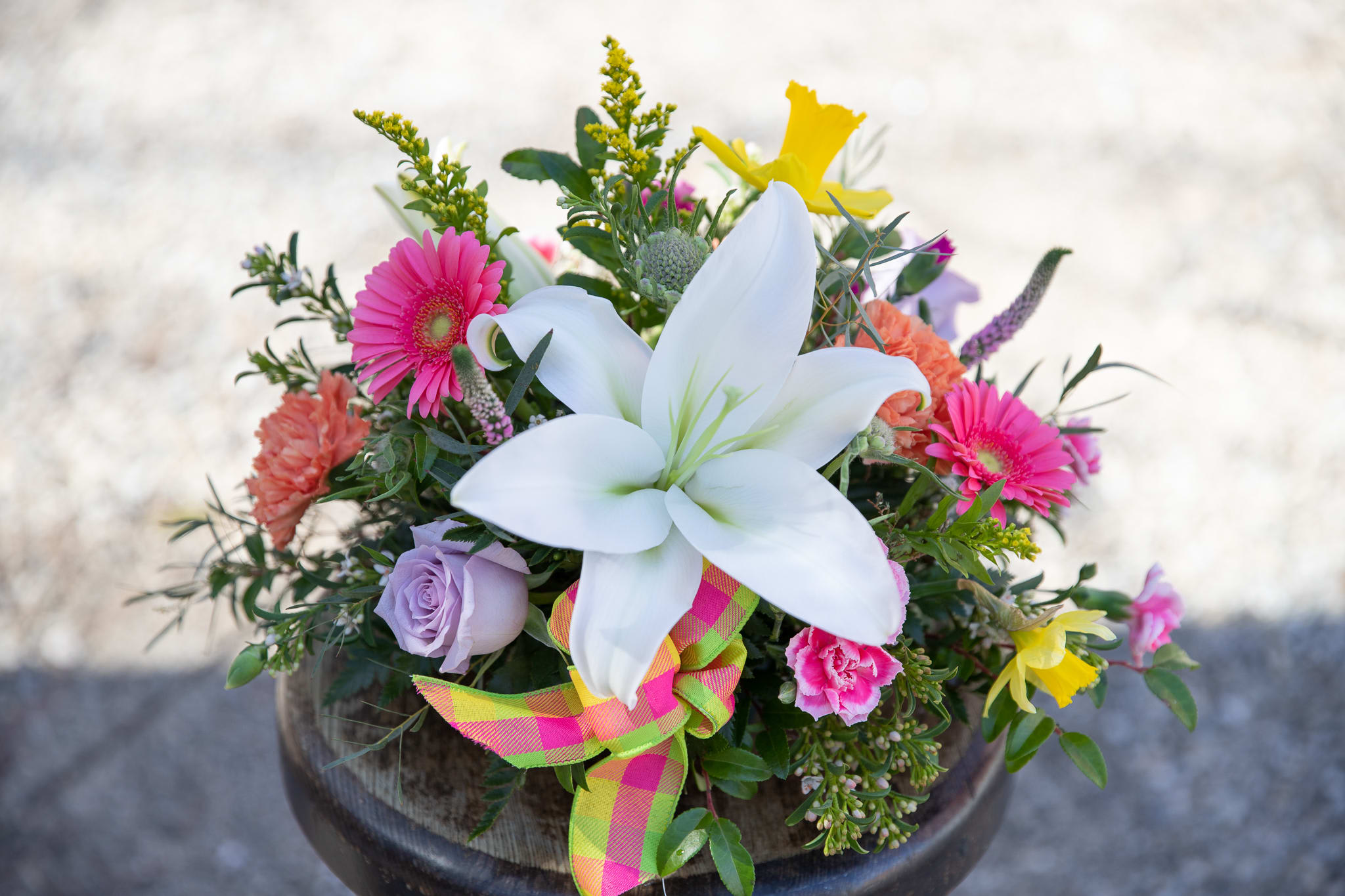 Easter Brunch Centerpiece - Some spring and Easter favorites designed in long and low fashion as to not disturb anyone's view or conversation across the table. Bring the season into your home with this lovely array of vernal specialty flowers. A fragrant focal flower of the beloved Easter lily will create just the ambiance your family gathering needs. Orientation is all around. Premium price is best for longer tables, families of 8-12 people. Deluxe, place settings of 6-8. Standard for 2-6.  
