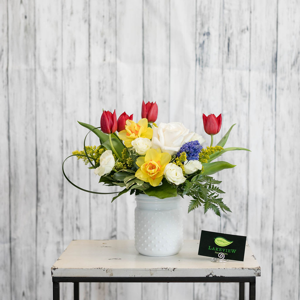Drama - Celebrate spring with vivid primary colors! Red tulips, yellow daffodils and blue hyacinth are the perfect choice to welcome a new season .  Approximate Dimensions: 12" H x 16" W 