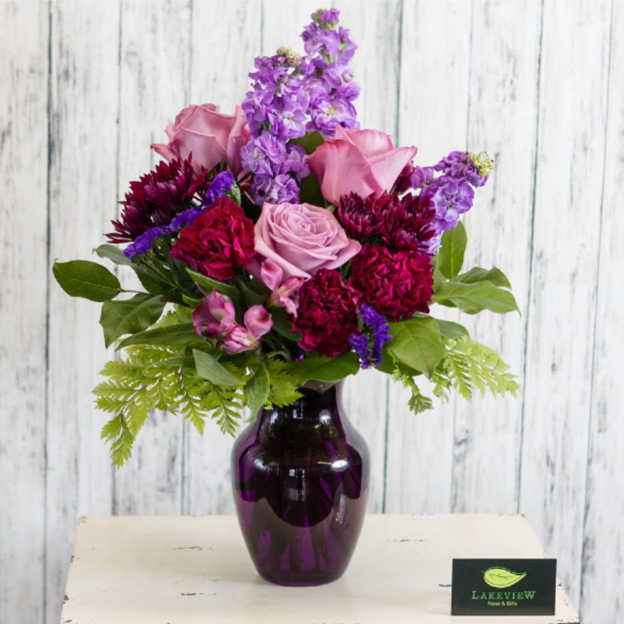 Pink and purple mixed bouquet in a dark glass vase