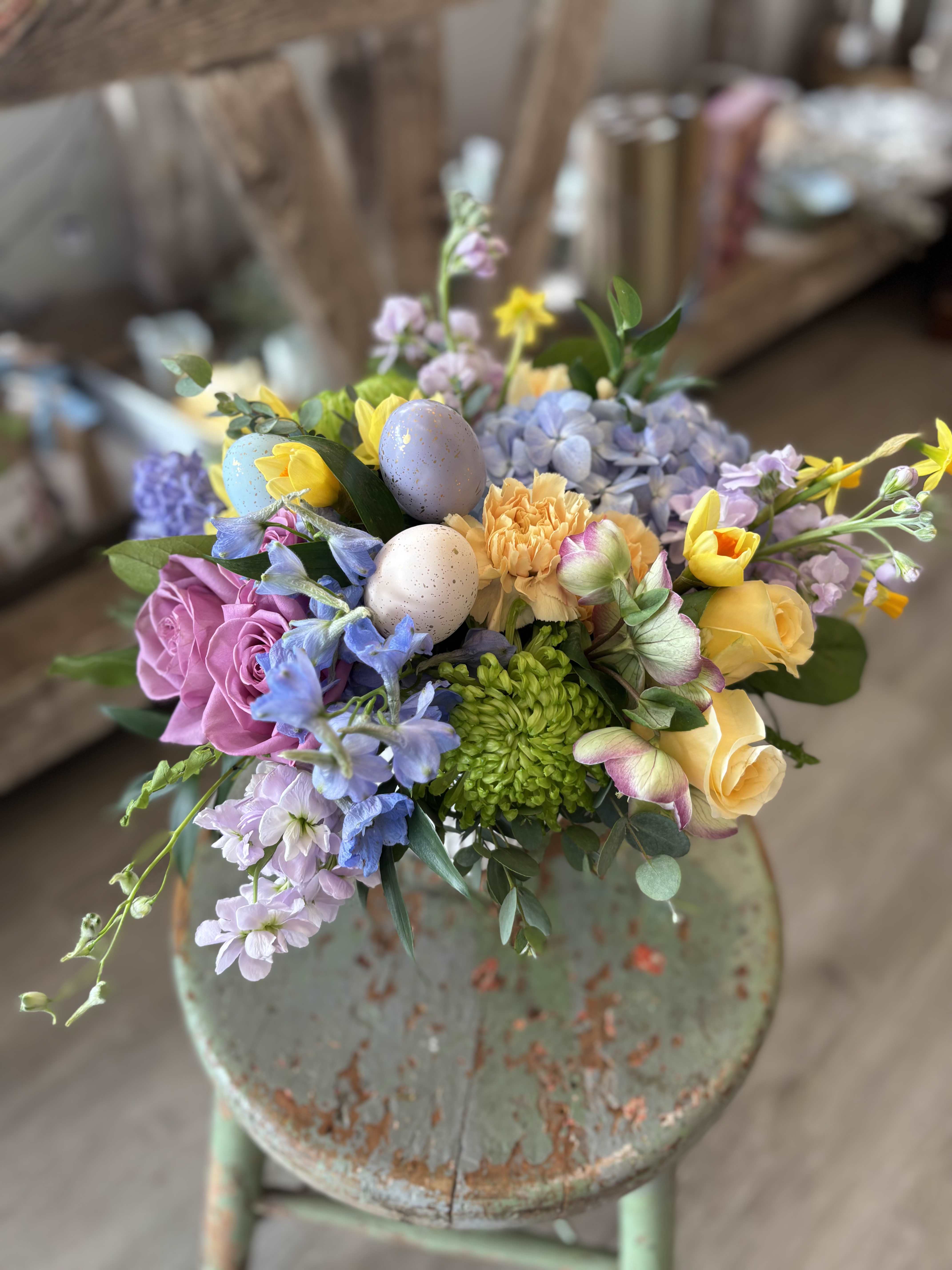 Robin's Nest  - A cheerful spring arrangement in soft pastels tones featuring some of our favorite seasonal blooms with an accent of speckled eggs nestled in the flowers - like a little Easter garden in full bloom.  This is a beautiful choice for an Easter centerpiece. 