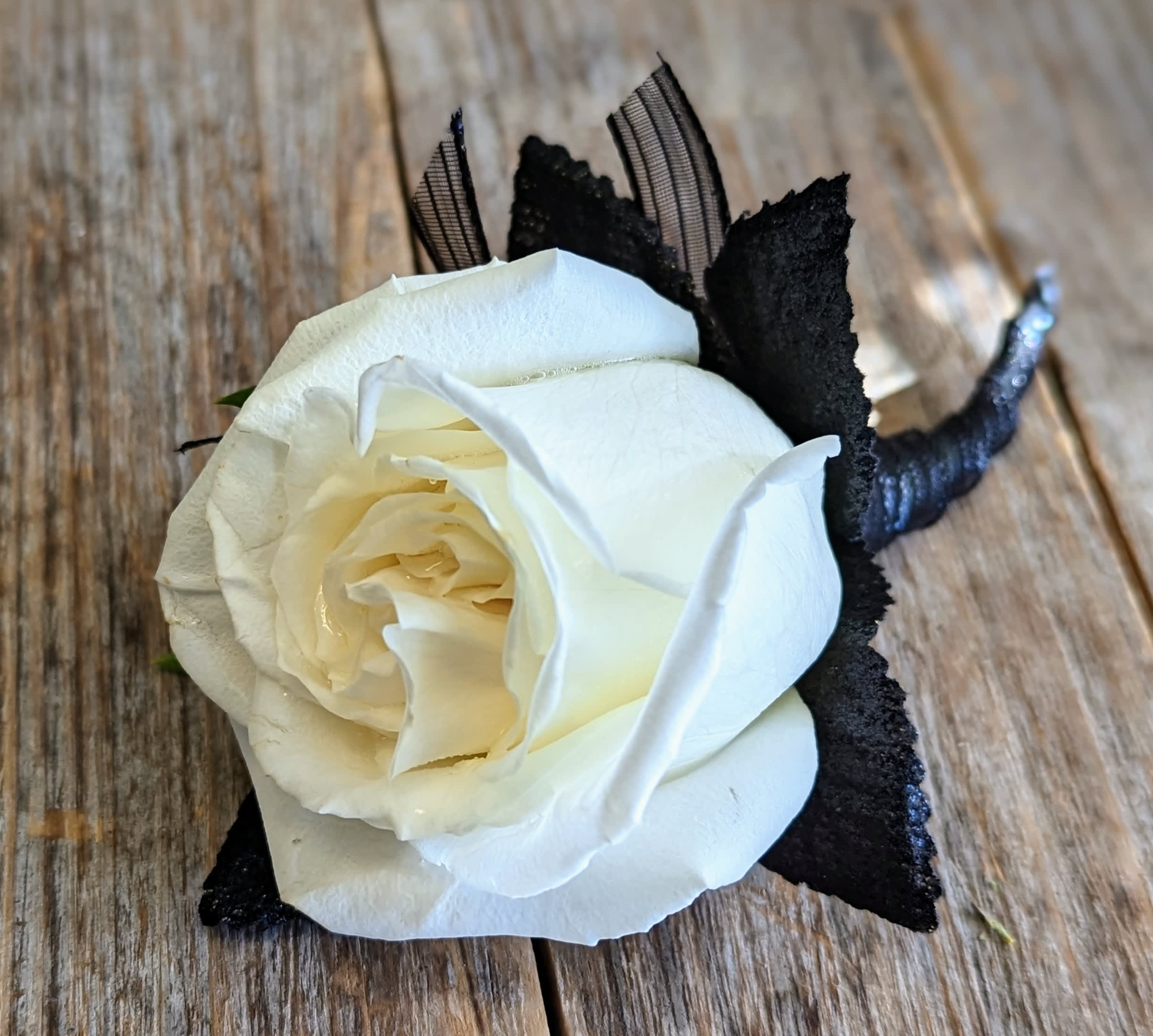 Single Rose Boutonniere - A single rose with simple greenery. This is available in other colors. This item is available for pickup only.
