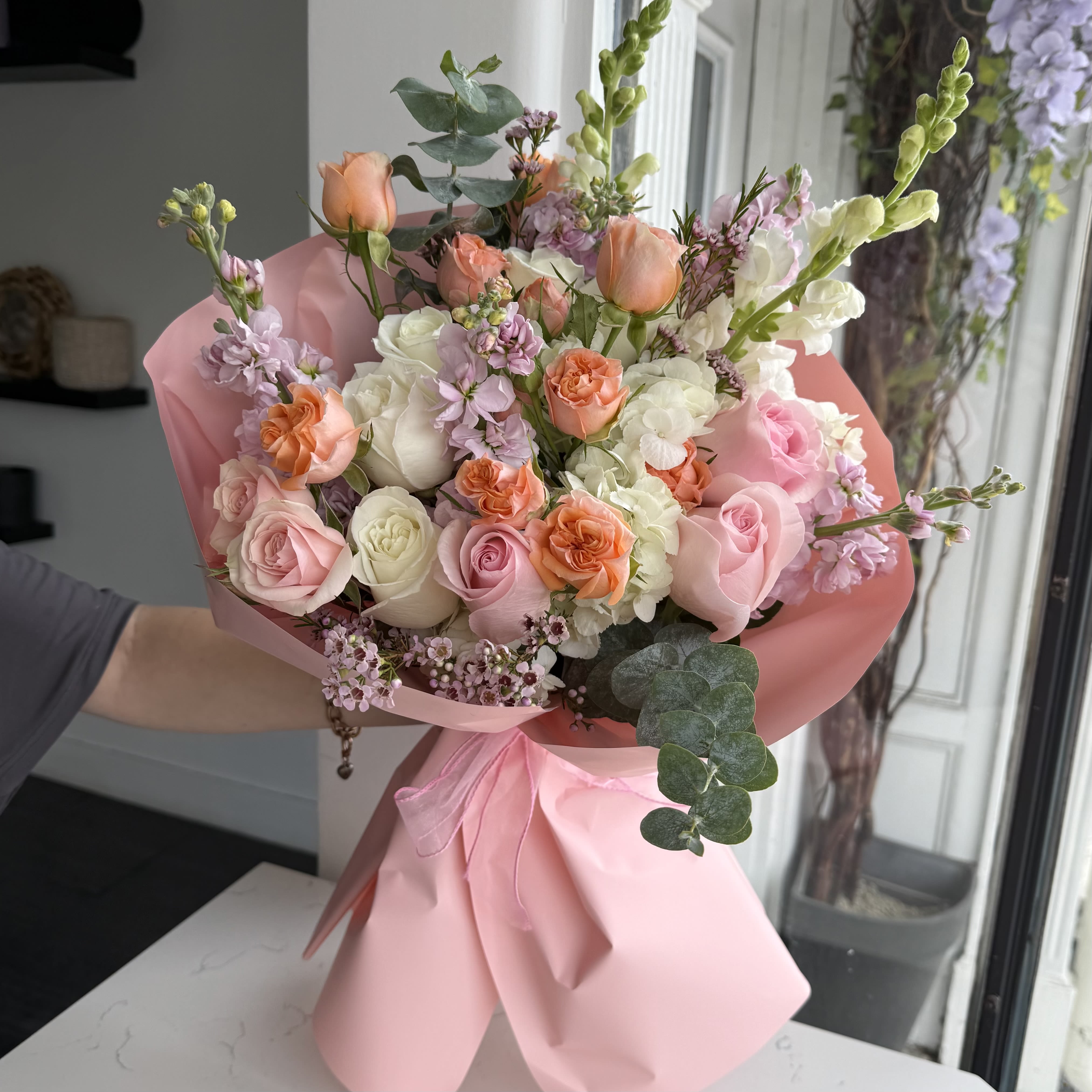 Mother's Day Bouquet - Designer choice bouquet (Flowers and colors can be different)  Celebrate love, care, and gratitude with the Mother’s Day Bouquet — a charming mix of soft pastels and fresh blooms, wrapped in delicate pink. Elegant and heartfelt, it’s the perfect way to show appreciation and make her day truly unforgettable.  Key Features:     •    Wrapped in soft pink for a graceful, feminine look     •    Finished with a ribbon for a polished touch     •    Available in Standard ($125), Deluxe ($165), Premium ($195) sizes     •    A beautiful gift to honor and celebrate moms everywhere  VASE NOT INCLUDED