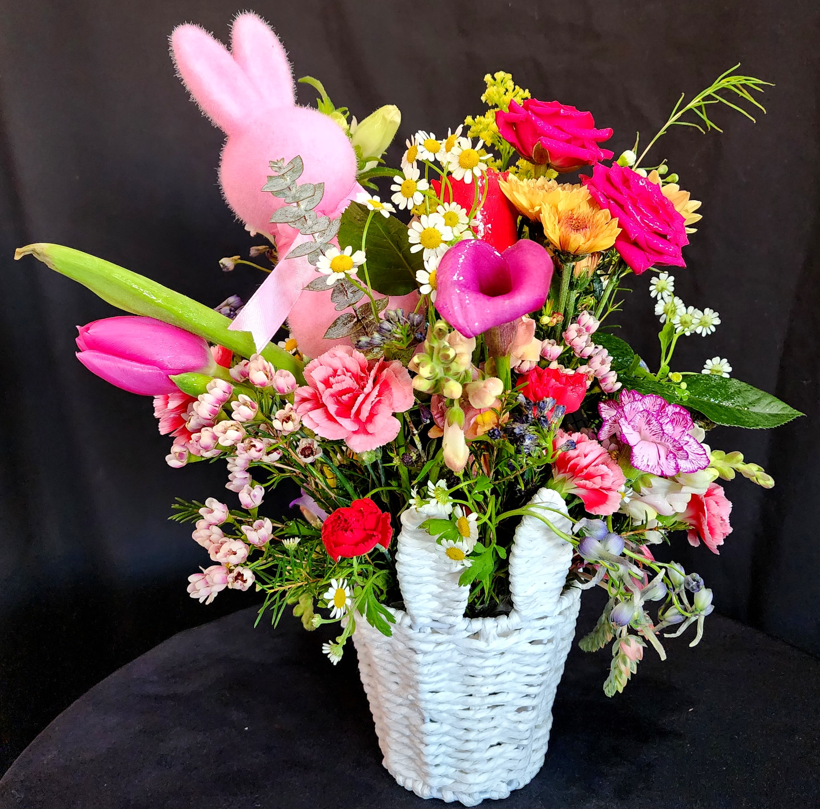 Hop into Spring! - Easter is around the corner and you can celebrate by giving a themed basket full of colorful flowers and a small bunny decoration. Flowers include spray roses, tulips, calla Lillies, carnations, wax, solidago and campanulas.  size is approximately 12 L x 14 H x 8 W  ****** Limited amount of 4 baskets available ******