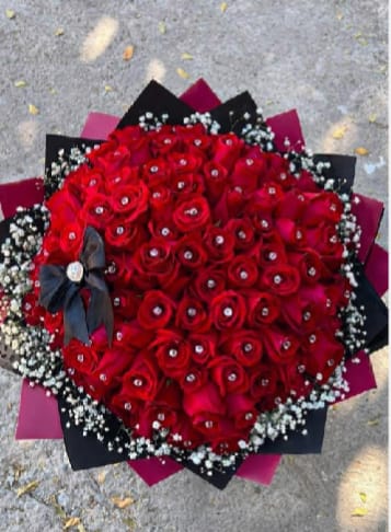 Eternal Romance Luxe Bouquet - A breathtaking luxury bouquet featuring 50–60 premium red roses, each delicately adorned with crystal rhinestones for an added touch of glamour.  Surrounded by soft baby’s breath and wrapped in elegant layered black and deep pink designer paper, this bouquet is finished with a sophisticated satin bow.  This arrangement symbolizes:    •   ️ Deep love    •    Luxury    •    Elegance    •    Timeless romance  Perfect for:    •   Anniversaries    •   Valentine’s Day    •   Romantic surprises    •   Luxury birthday gifts    •   “Just because” moments  Bold. Elegant. Unforgettable.  ⸻   Details    •   50–60 Premium Red Roses    •   Crystal rhinestone accents    •   Baby’s breath detailing    •   Luxury black &amp; deep pink wrap    •   Satin bow finish    •   Approx. width: 22–26 inches    •   Premium presentation