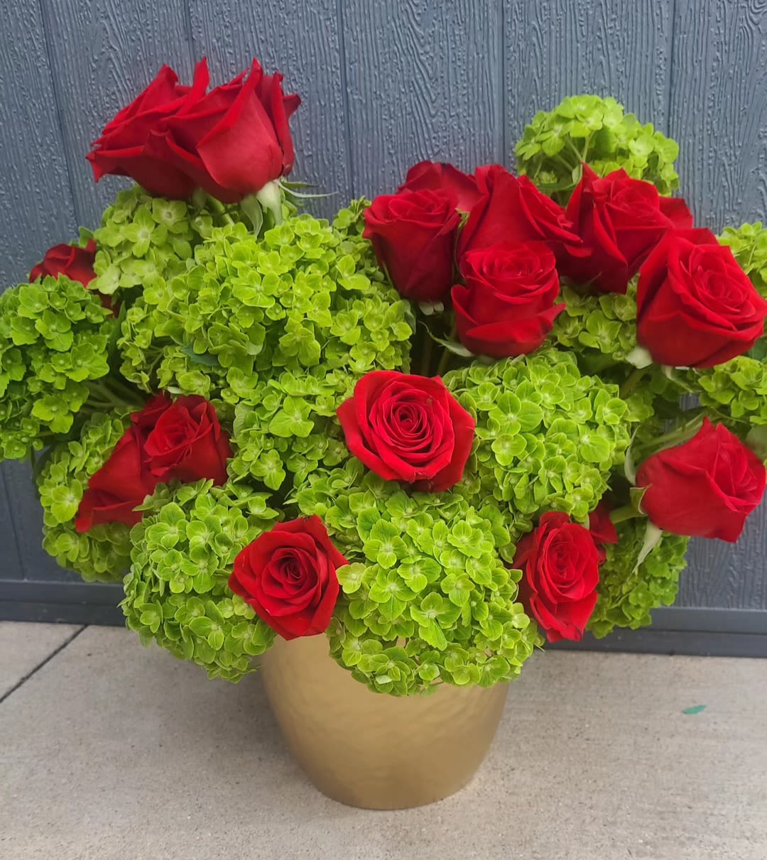Emerald Romance  - A bud and refreshing arrangement featuring vibrant green hydrangeas pairs with classic red roses. Tis striking design blends modern color contrast with timeless romance, making it perfect for special occasions or a statement gift.