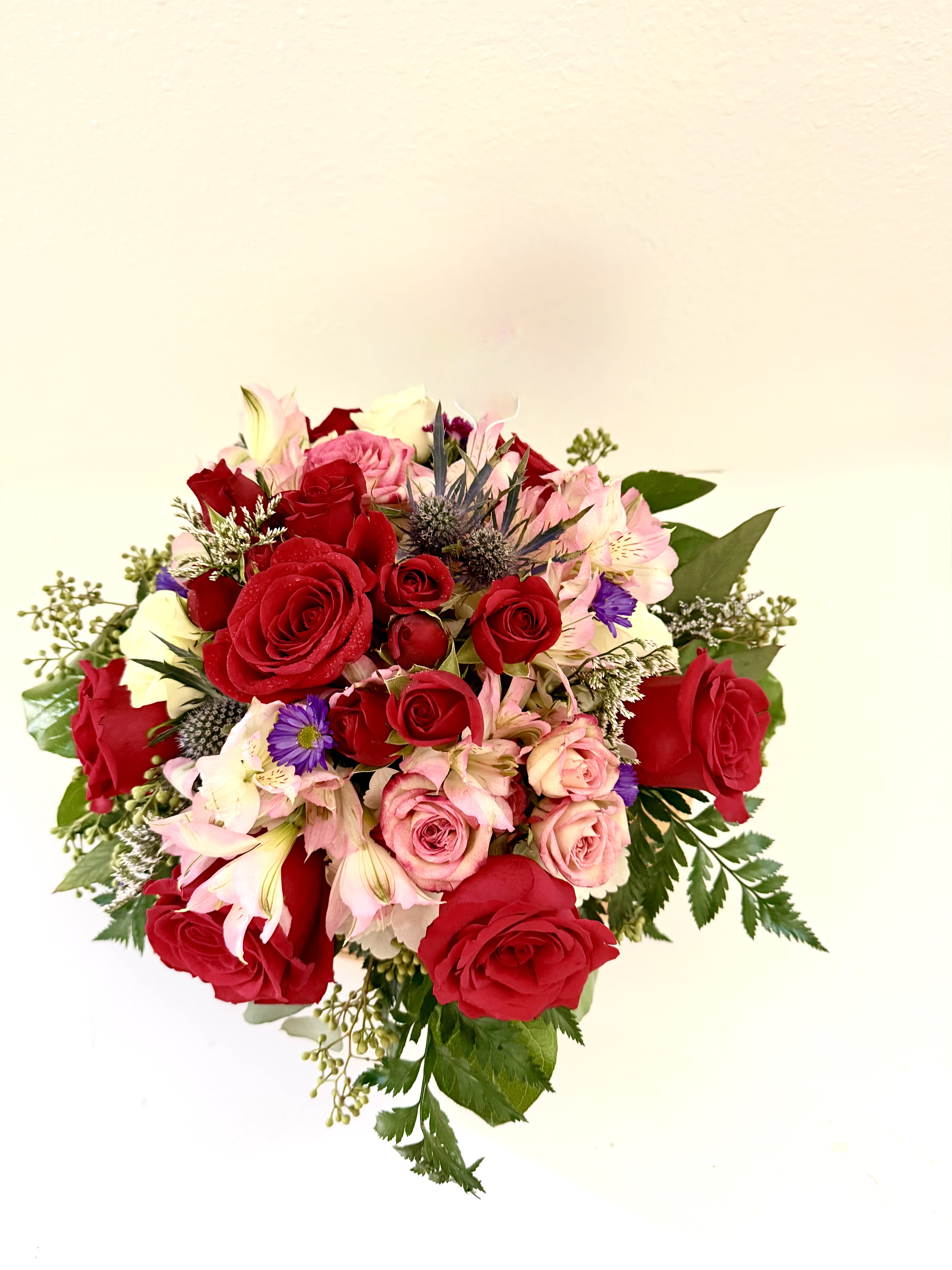 First love - This stunning arrangement features lush red roses and delicate spray roses, beautifully complemented by full hydrangeas and soft accent blooms.The rich crimson tones create a striking display of love and admiration, while the textured hydrangeas add depth and fullness.Designed with balance and grace, it makes a bold yet sophisticated statement for any heartfelt occasion, and it can be customized in a variety of color palettes—simply call the studio to create your perfect combination.For same day delivery and Free Delivery Options Text or Call  832-973-1376. 