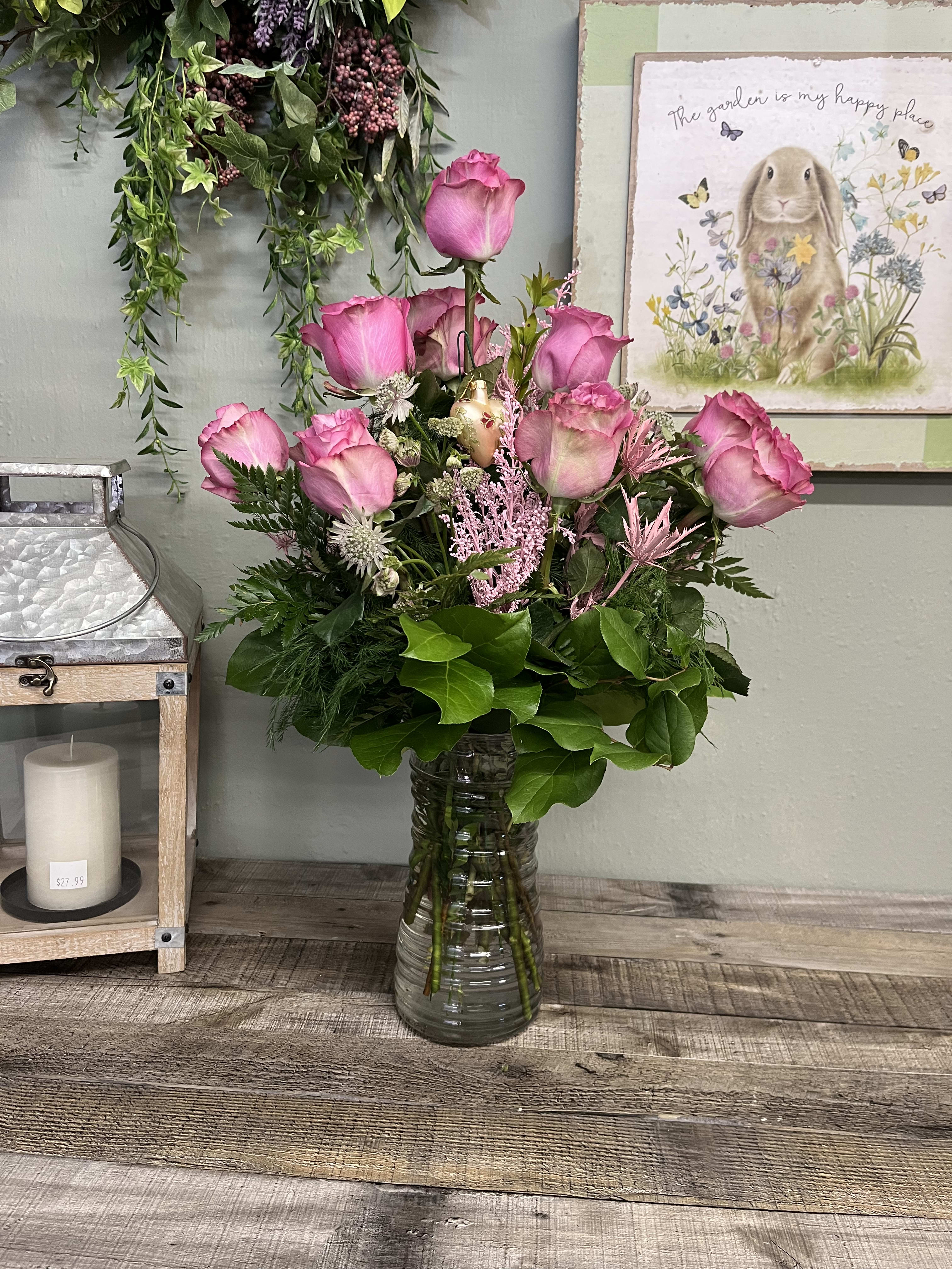 Dozen Purple Roses - An all rose arrangement of purple  roses. A clear glass vase with 12 Roses, greenery and filler flowers. 