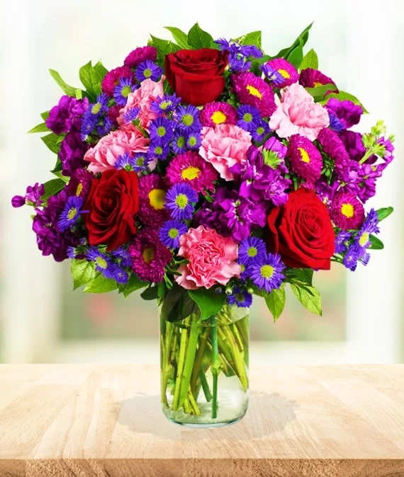 AVA Floral Harmony - A vibrant blend of red, purple, pink and lavender make up this special bouquet, all brought together in a clear vase.