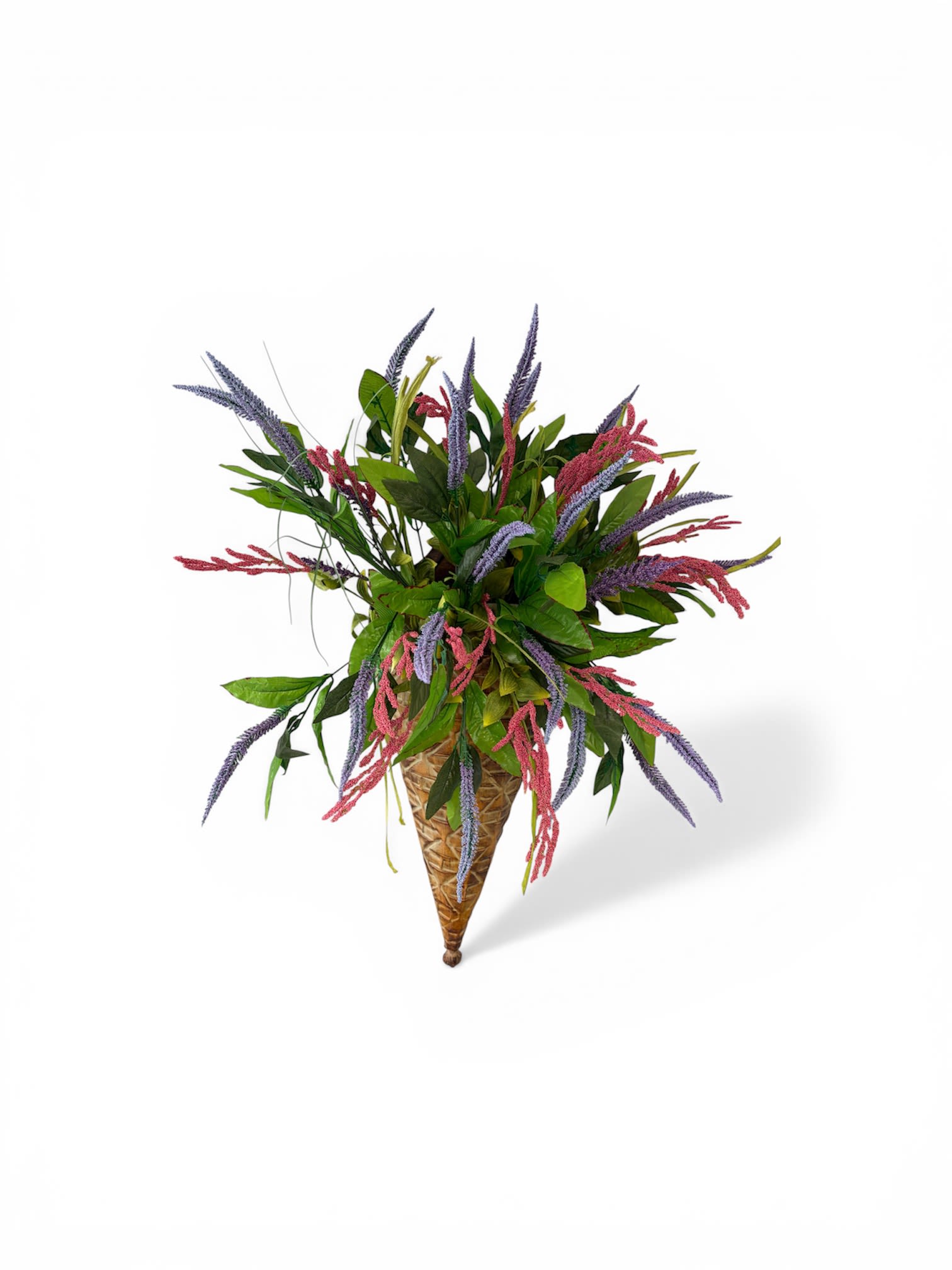 unique silk wall piece - A lively spray of slender pink and purple spiky blooms arcs outward from a tapered woven cone-shaped wall basket, creating an eye-catching silk wall piece perfect for brightening an entryway or casual living space. As a flower arrangement for home décor or a thoughtful housewarming gift, this vertical accent brings a fresh, slightly wild energy that reads as both modern and rustic-an ideal choice for someone who loves color and texture on their walls.  The silk stems are mixed with abundant broad green foliage for a full, textural look that balances upright and gently cascading lines. The warm brown woven cone emphasizes the vertical silhouette and makes hanging easy, while the mixed pinks, purples, and greens give the piece seasonal versatility without needing maintenance. Designed to look natural from every angle, it's the kind of wall accent that will make the person you're thinking of feel genuinely seen and welcomed the moment they step inside.