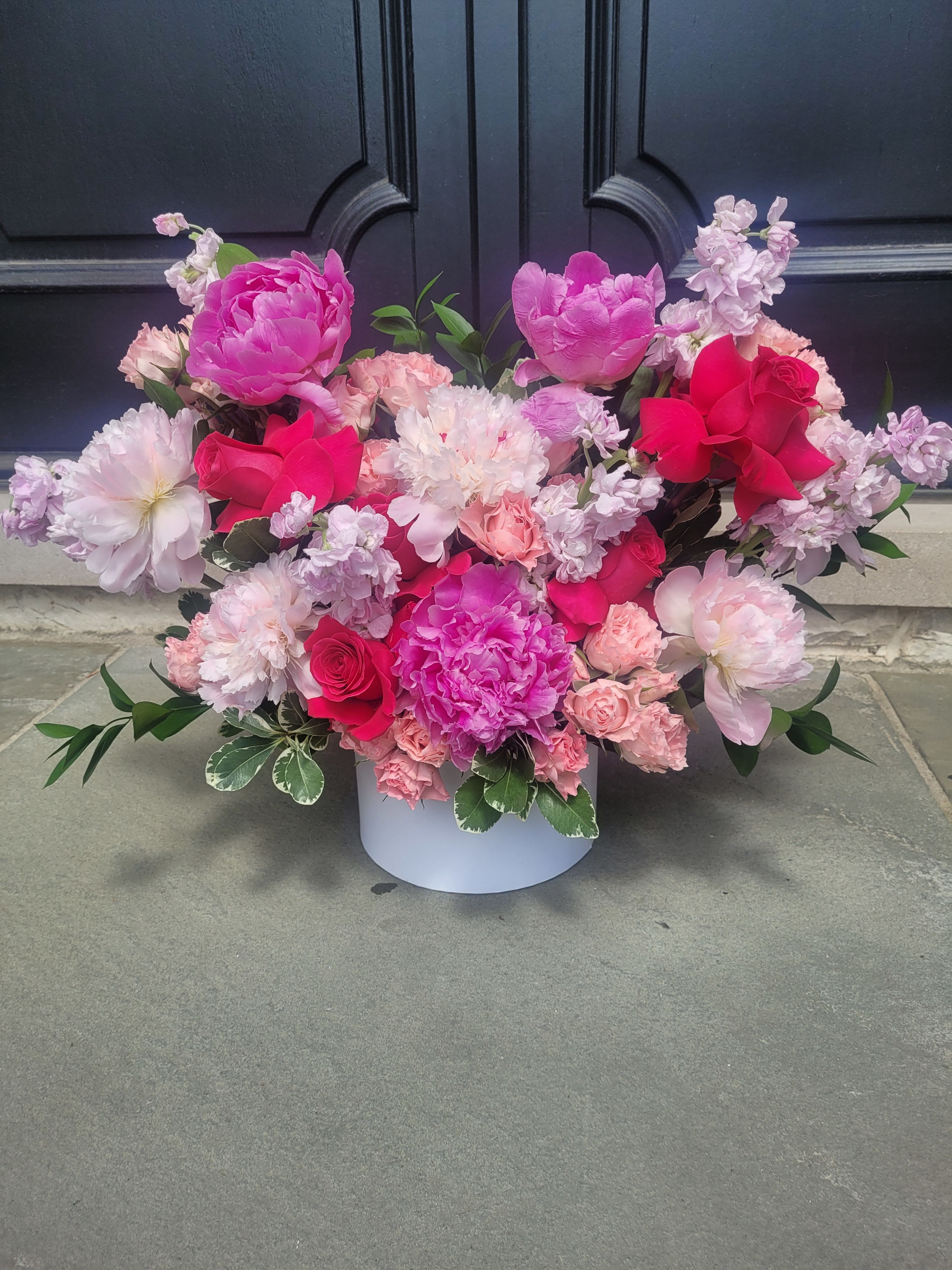 Peony Garden - A lush, romantic arrangement featuring peonies, roses, and complementary filler blooms, accented with fresh greenery. Elegantly presented in a hat box for a soft, modern, and luxurious look.