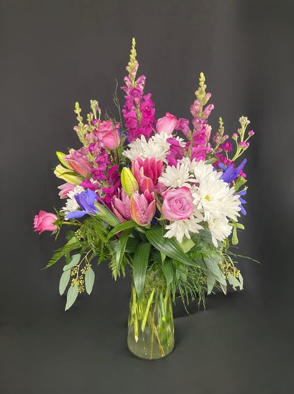 Anything For You - Show her just how much she means to you. Love has no limits and neither does this bouquet. Purple snapdragons and stock climb above lavender roses, stargazer lilies, white daisies, and purple iris.