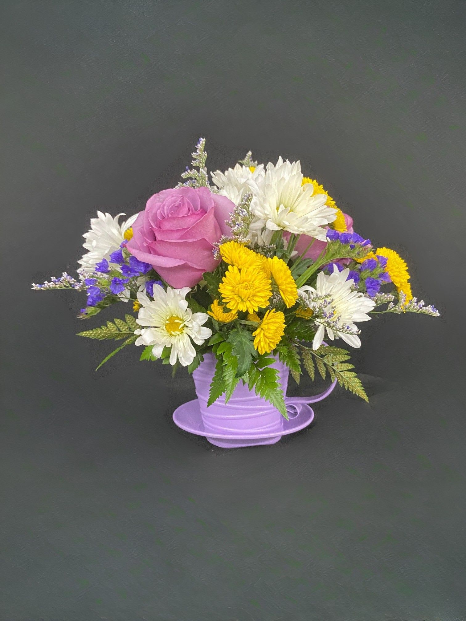 Teacup O' Delight - This cute metal teacup comes in several colors (Green, Purple, Orange, Red, Pink &amp; Yellow) and is overflowing with beautiful accent flowers such as roses, carnations, daisies, mini-carnations, gerberas, and iris. Color assortment will vary, please enter any requests in the SPECIAL INSTRUCTIONS box when ordering!
