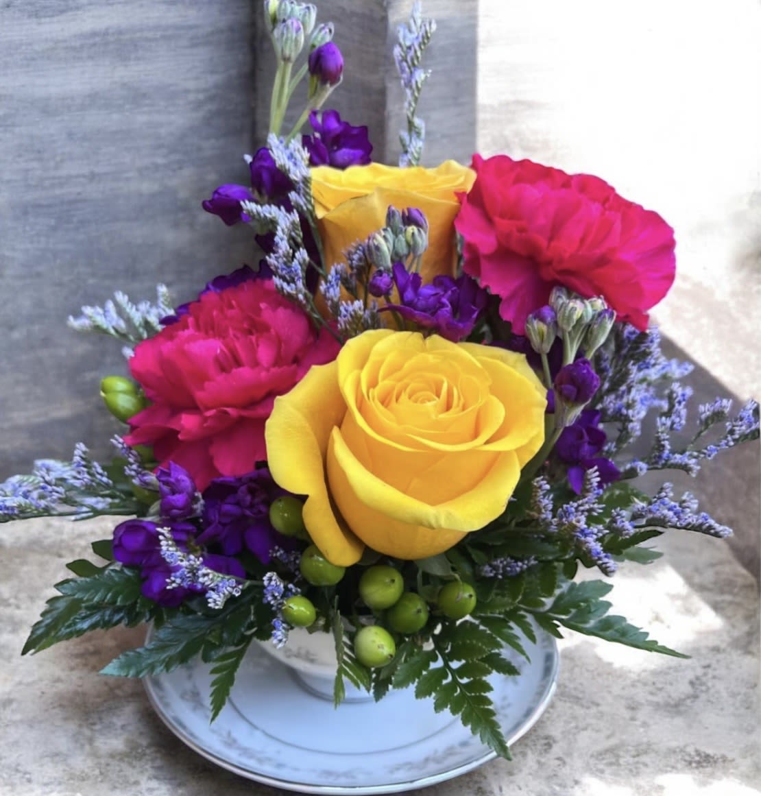 Sipping Paradise Tea Cup - This arrangement has roses, stock, hypericum, limonium, carnations and greenery. 