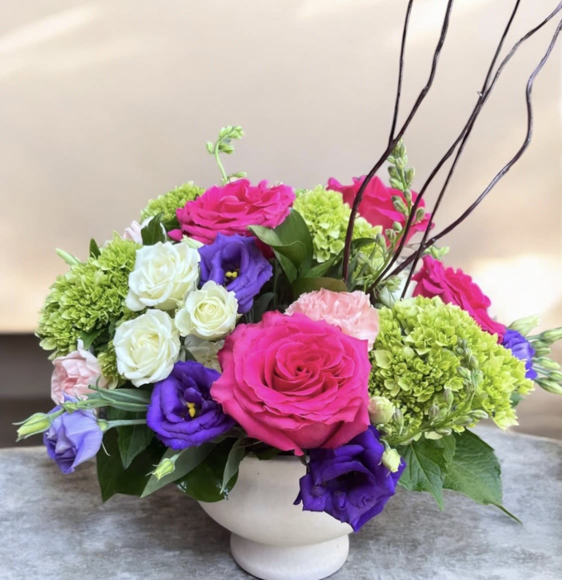 Sweet Gardens  - This arrangement has green hydrangea’s, hot pink roses and purple lisianthus, white pray roses, light pinks carns, Curley willow with beautiful greenery. 